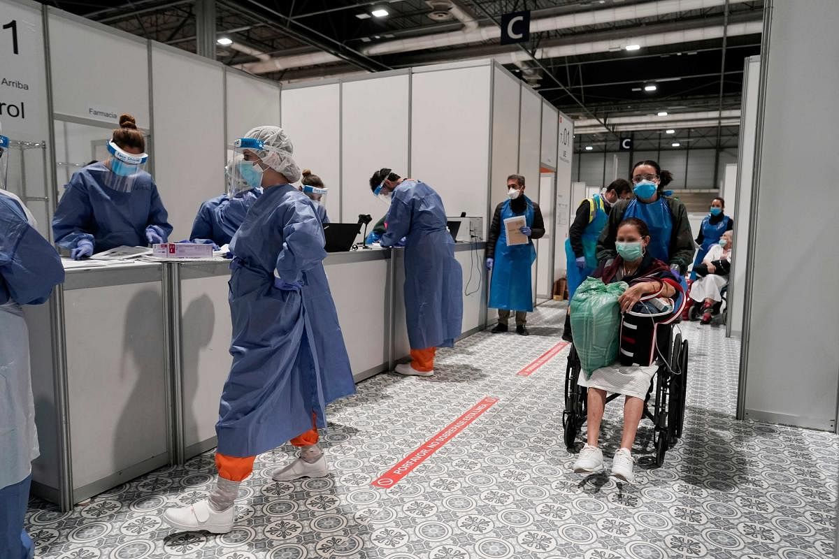 Healthcare workers work at the temporary hospital for COVID-19 patients located at the Ifema convention and exhibition centre in Madrid. Handout / COMUNIDAD DE MADRID / AFP