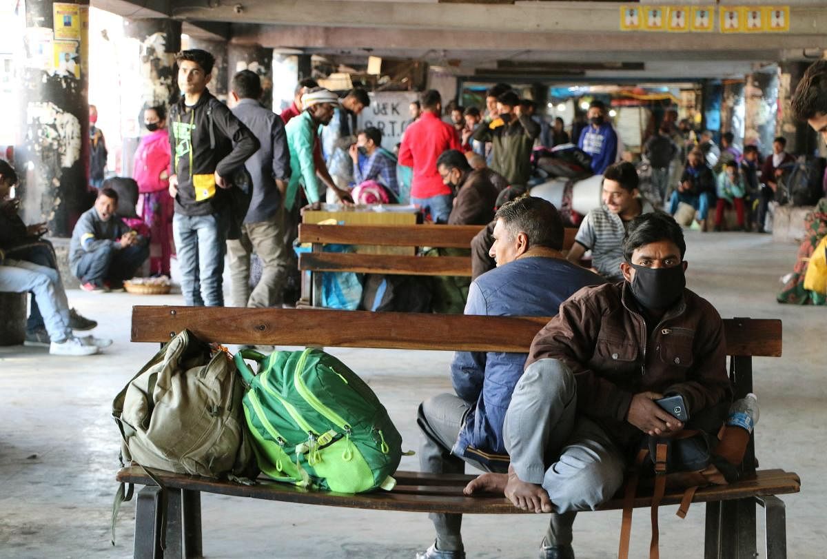  Stranded passengers sit as they look for public transport after authorities banned interstate bus service in the wake of coronavirus pandemic, in Jammu, Friday, March 20, 2020. (PTI Photo)