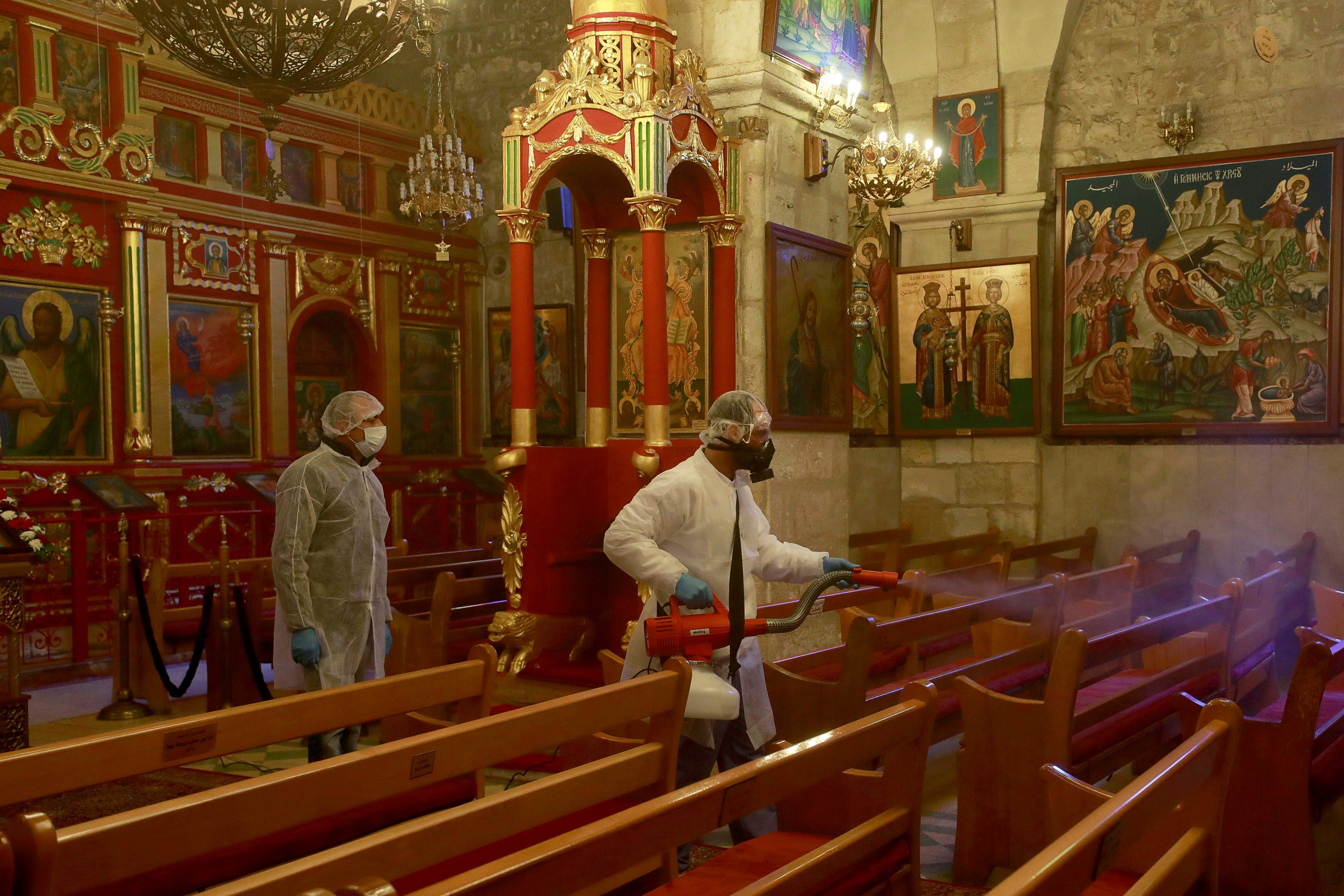 Palestinian workers disinfect a church as a preventive measure against the coronavirus, in Ramallah in the in the Israeli-occupied West Bank. (Credit: Reuters)
