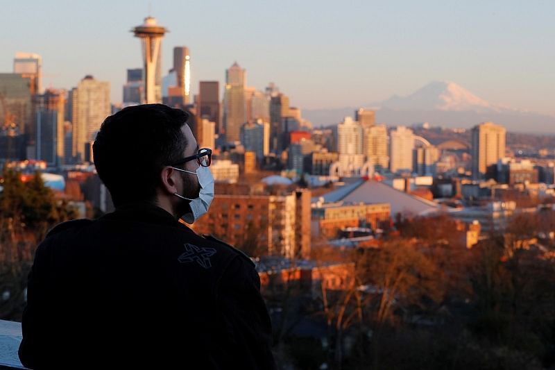 A man wearing a mask, amid the coronavirus (COVID-19) outbreak, looks out from Kerry Park overlooking Seattle, Washington. (Reuters Photo)