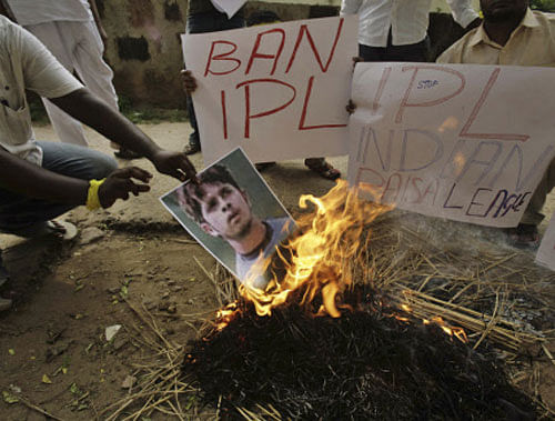 Activists of Kalinga Sena, a local political party, hold placards as they burn a poster of Indian cricketer Shanthakumaran Sreesanth at a protest against spot fixing during the Indian Premier League (IPL) in Bhubaneswar, Friday, May 17, 2013. A fourth player has been suspended by the Board of Control for Cricket after authorities said Friday he was among the bookmakers arrested by police along with three other cricketers, including Sreesanth, for alleged spot-fixing in a domestic Twenty20 league tournament. AP Photo