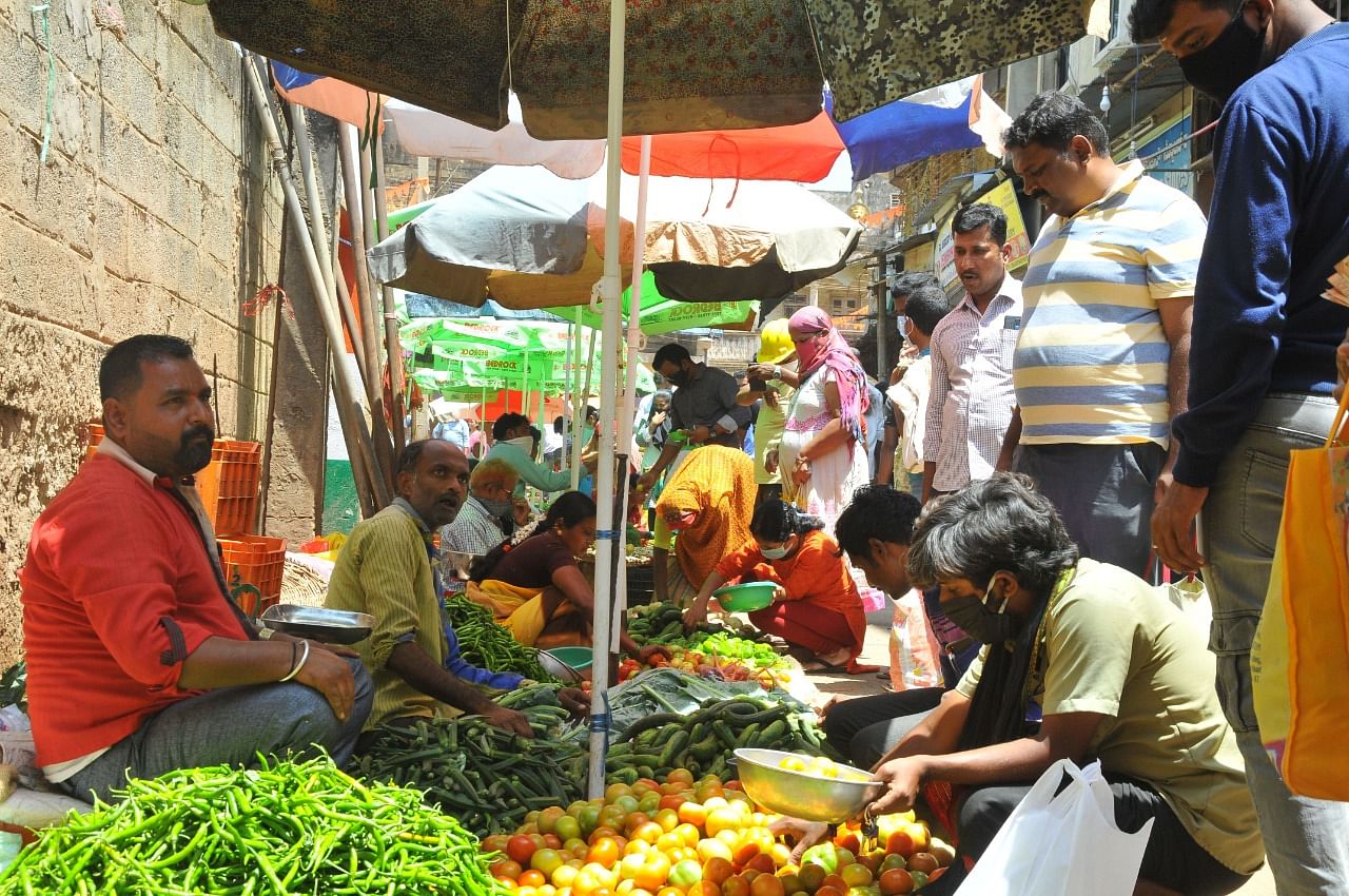 People buying vegetables at Janata Bazar in Hubballi on Monday. (Credit: DH photo)