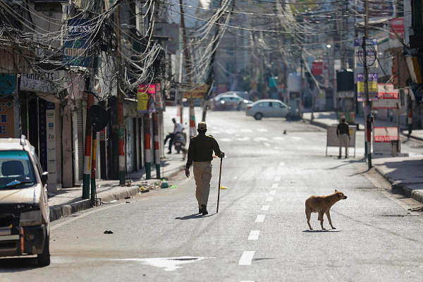 A policeman walks along a deserted road during 'Janata curfew' in the wake of coronavirus pandemic, in Jammu, Sunday, March 22, 2020. (PTI Photo)