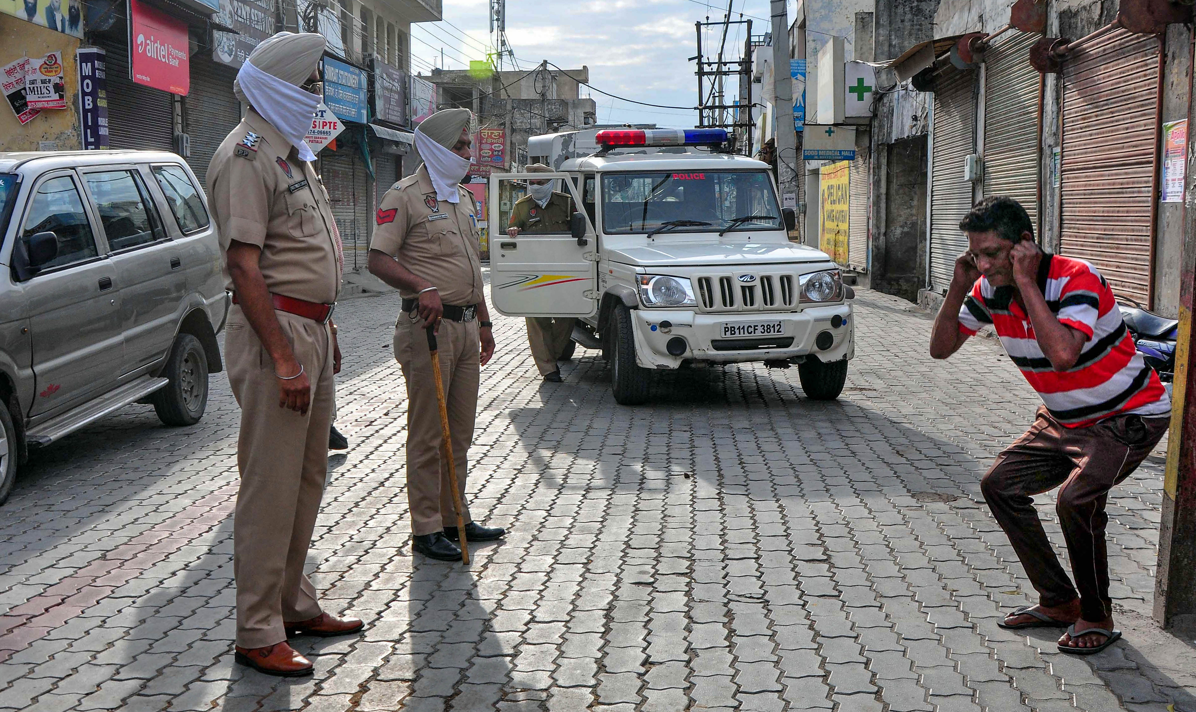  Police personnel punish an offender for flouting guidelines on lockdown, put in place in the view of coronavirus pandemic, in Patiala. (Credit: PTI Photo)