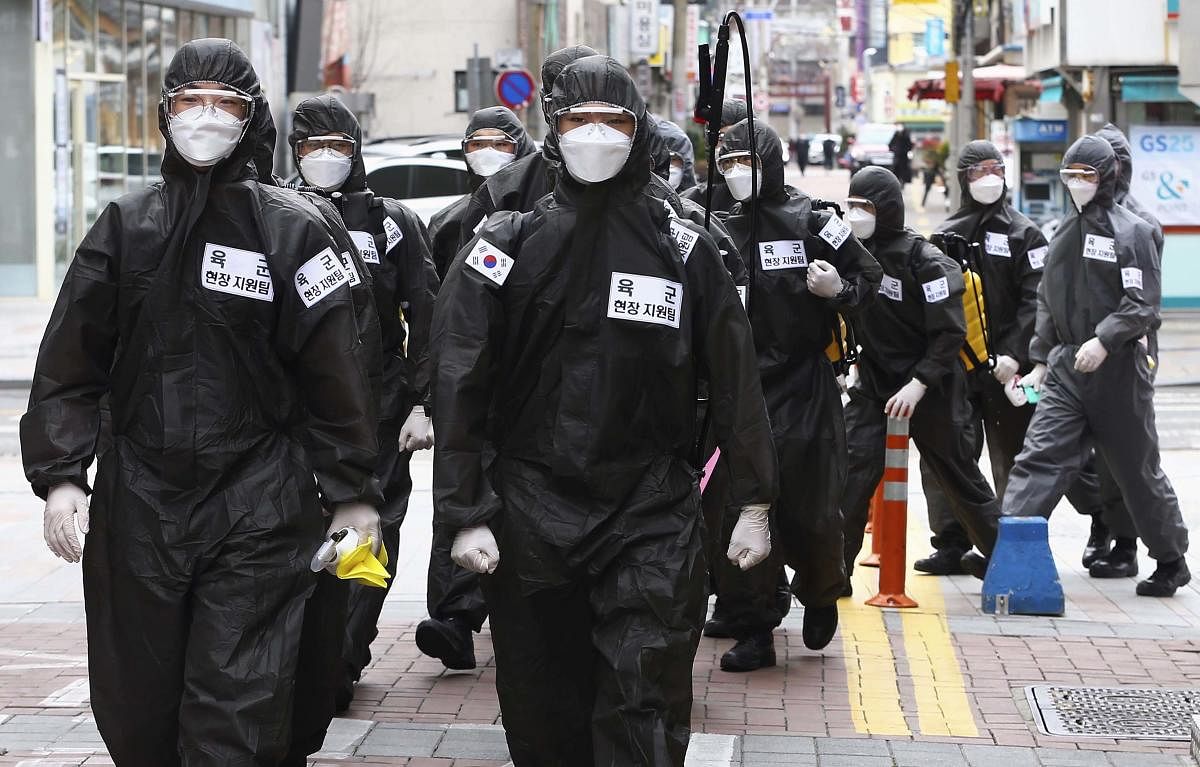  South Korean army soldiers wearing protective suits move to spray disinfectant in Daegu, South Korea. (AP Photo)