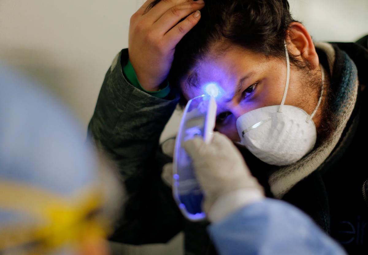 Medical staff checks temperature amid COVID-19 fears (AFP Photo)