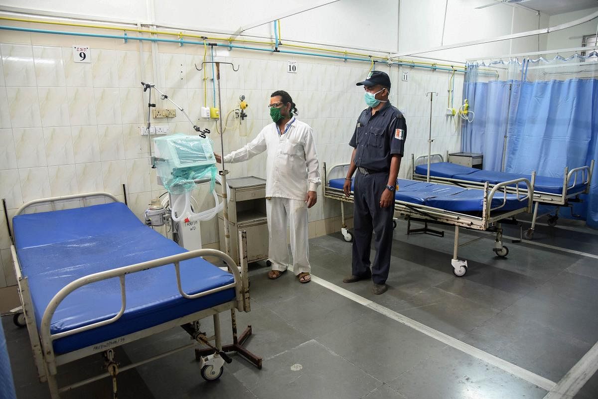 A medic and security person wearing mask in view of coronavirus pandemic are seen inside an isolation ward of NMMC hospital, in Navi Mumbai, Saturday, March 14, 2020. (PTI Photo)