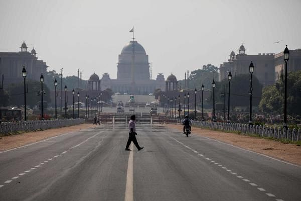 A man crosses a deserted Rajpath during a nationwide one day Janata (civil) curfew imposed as a preventive measure against the COVID-19 coronavirus in New Delhi on March 22, 2020. (Credit: AFP Photo)