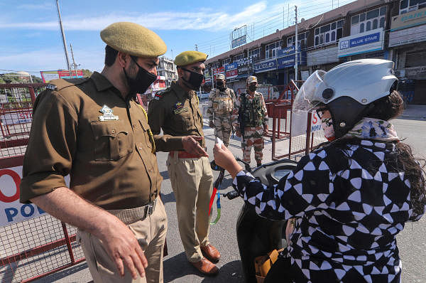 Police officials check ID cards of commuters after lockdown due to the coronavirus outbreak, in Jammu, Monday, March 23, 2020. (PTI Photo)