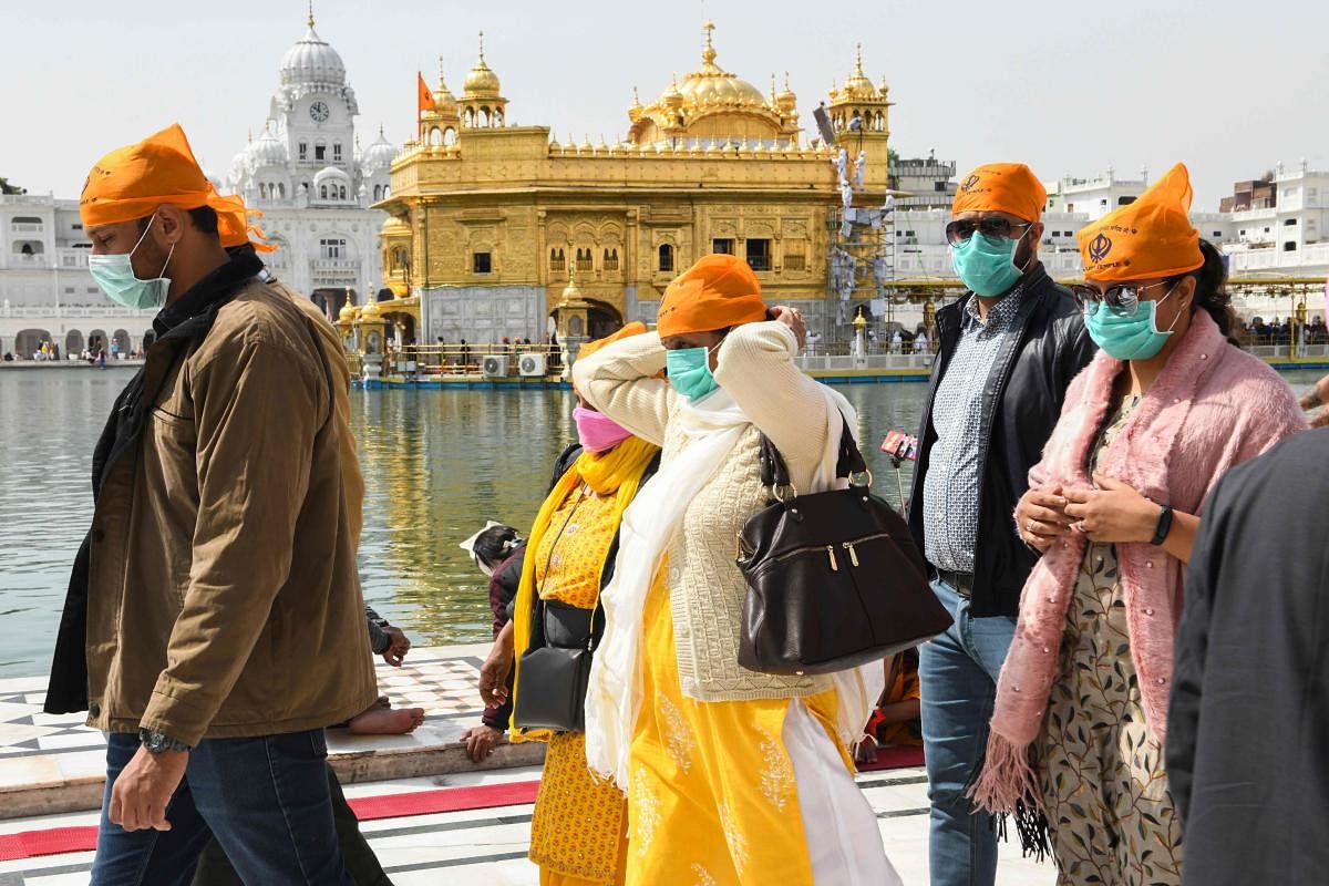 Devotees, wearing facemasks amid concerns over the spread of the COVID-19 novel coronavirus, arrive to pray at the Golden Temple in Amritsar on March 13, 2020. Credit: AFP Photo