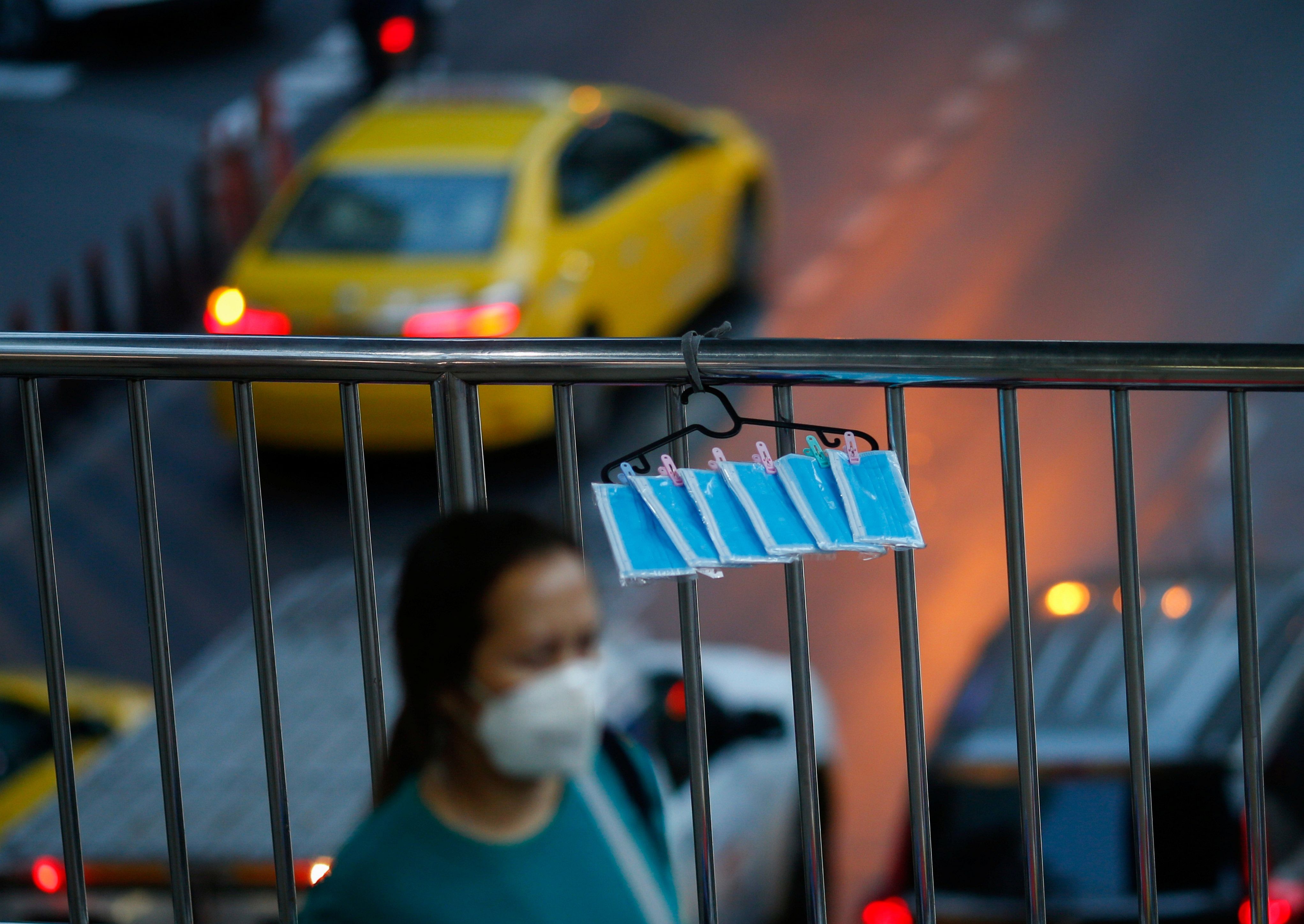 Protective face masks sold by a vendor are seen hanging on a fence following the coronavirus disease (COVID-19) outbreak in Bangkok, Thailand. (Credit: Reuters)