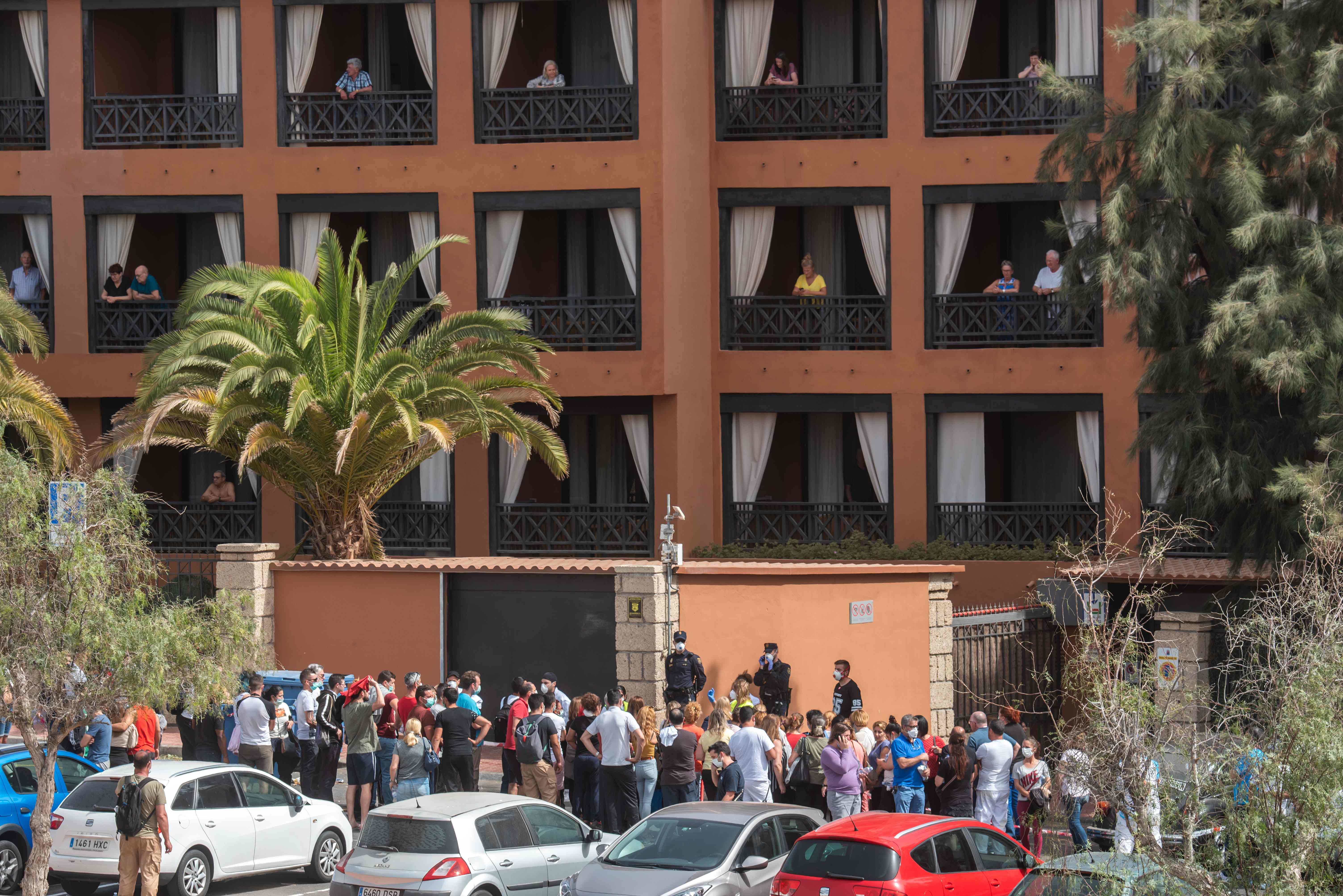 A psychologist talks to a group of workers outside the H10 Costa Adeje Palace Hotel in La Caleta. (AFP Photo)