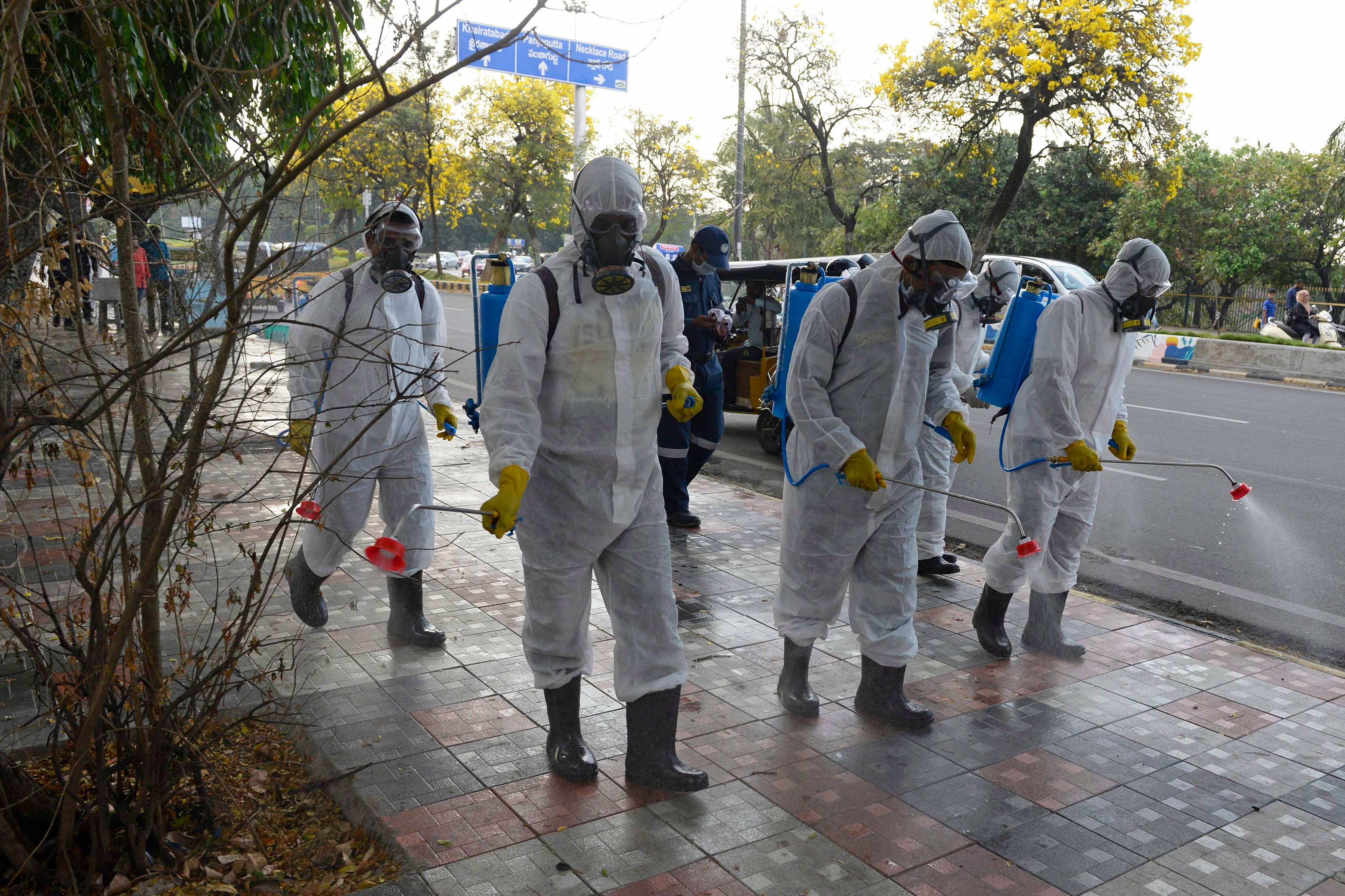 Members from Disaster Response Force (DRF) of Telangana State, wearing protective gear spray disinfectant on a pedestrian footpath amid concerns over the spread of the COVID-19 novel coronavirus. (AFP Photo)
