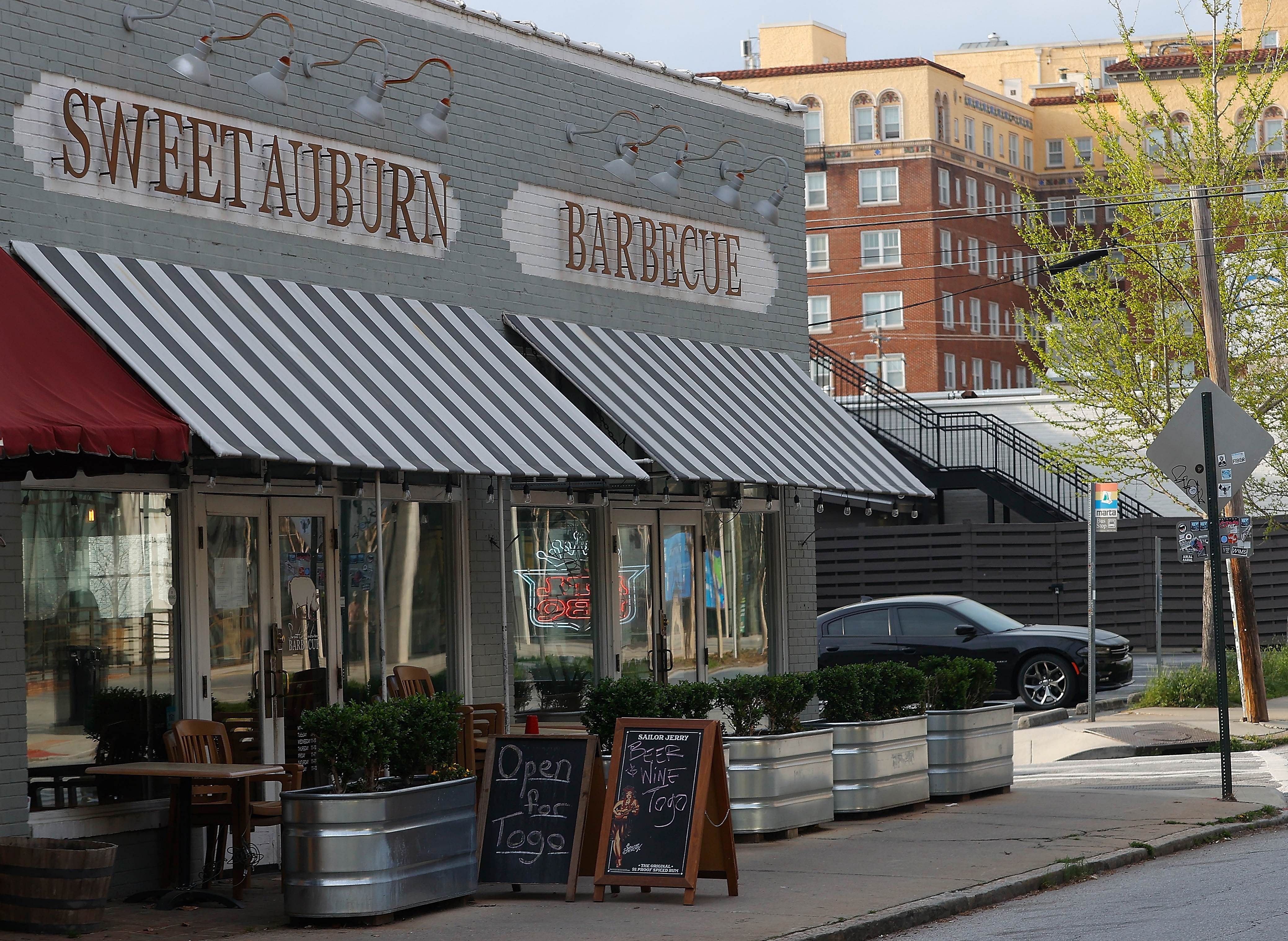 Signs are seen outside Sweet Auburn Barbecue as beer and wine is also available with their to go food orders. (AFP Photo)