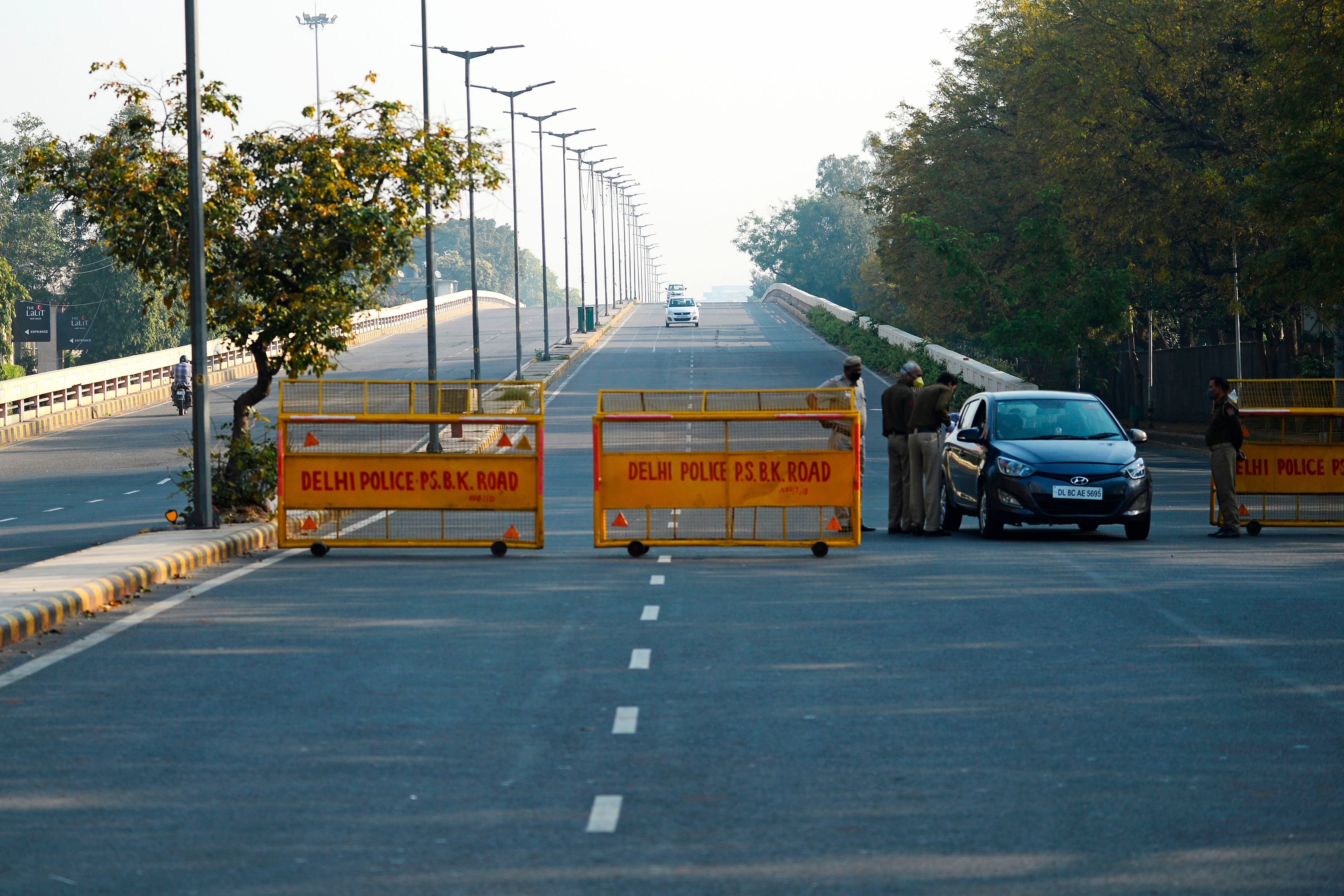 Police personnel speaks to a car driver on a deserted road during a one-day Janata (civil) curfew imposed amid concerns over the spread of the COVID-19 novel coronavirus, in New Delhi. (Credit: AFP)