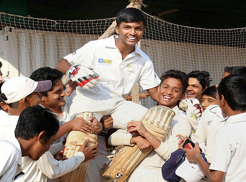 Pranav Dhanavade is lifted by his friends as thay celebrate after he created a world record by scoring 1009 runs in an Under 16 MCA cricket match in Kalyan, in Mumbai on Tuesday. PTI Photo