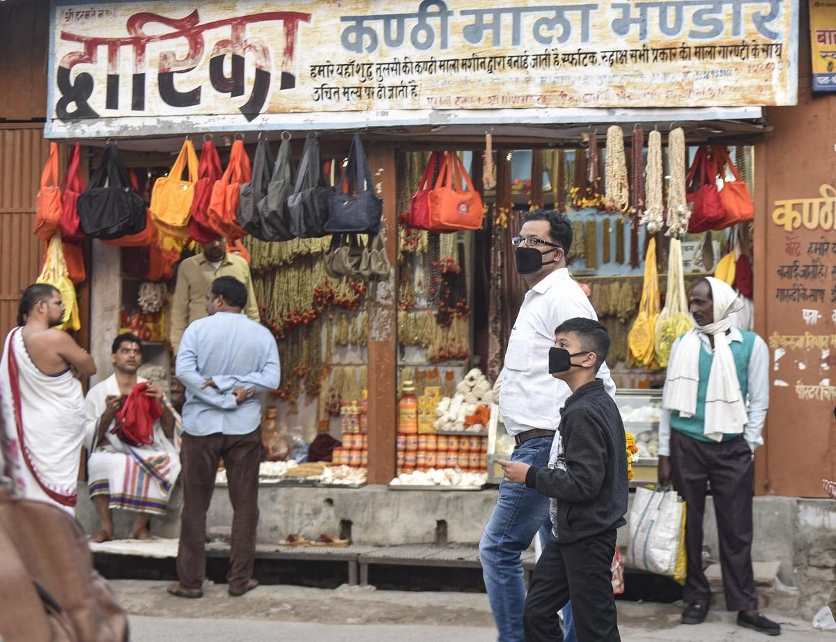 People wearing protective masks in the wake of coronavirus pandemic walk along Ramlala market in Ayodhya, Saturday, March 14, 2020. (PTI Photo)