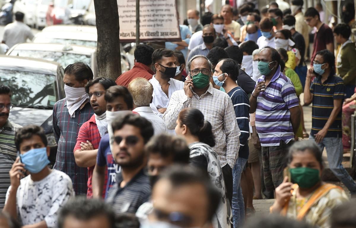 People stand in a queue to collect LPG cylinders during a 21-day nationwide lockdown in the wake of coronavirus pandemic, at Girgaon in Mumbai, Wednesday, March 25, 2020. (PTI Photo) 