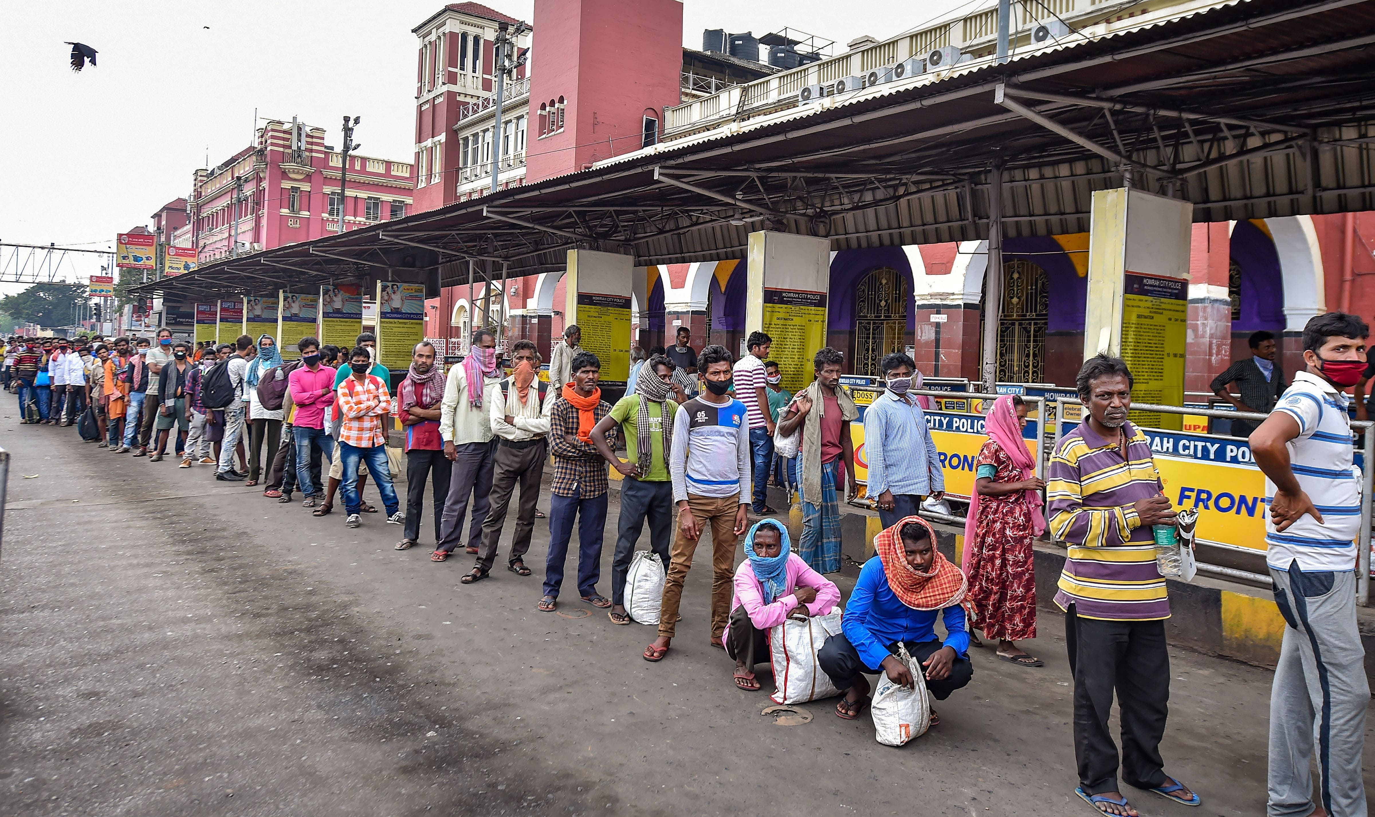 Stranded passengers at the Howrah Railway Station stand in a queue for free food, being distributed by a social organisation, during the complete lockdown imposed in the wake of coronavirus pandemic, in Kolkata. (Credit: PTI Photo)
