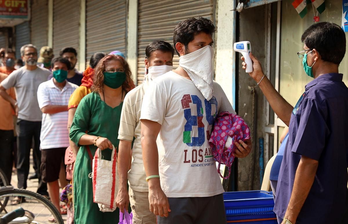 A worker screens customers outside a grocery store during a 21-day nationwide lockdown in the wake of coronavirus pandemic, in Thane, Wednesday, March 25, 2020. (PTI Photo) 