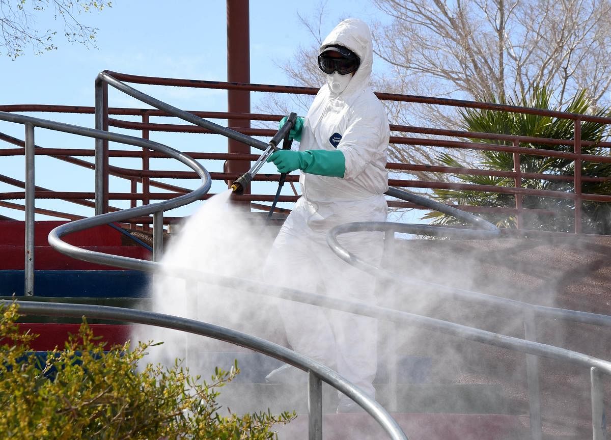 Worker cleaning amid COVID-19 pandemic (AFP Photo)