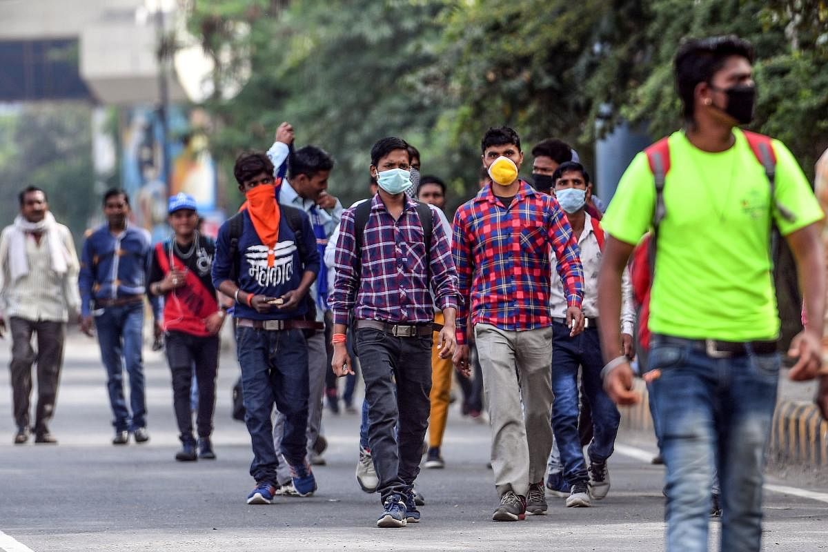 People, of some wearing facemasks, walk on a road amid COVID-19 crisis (AFP Photo)