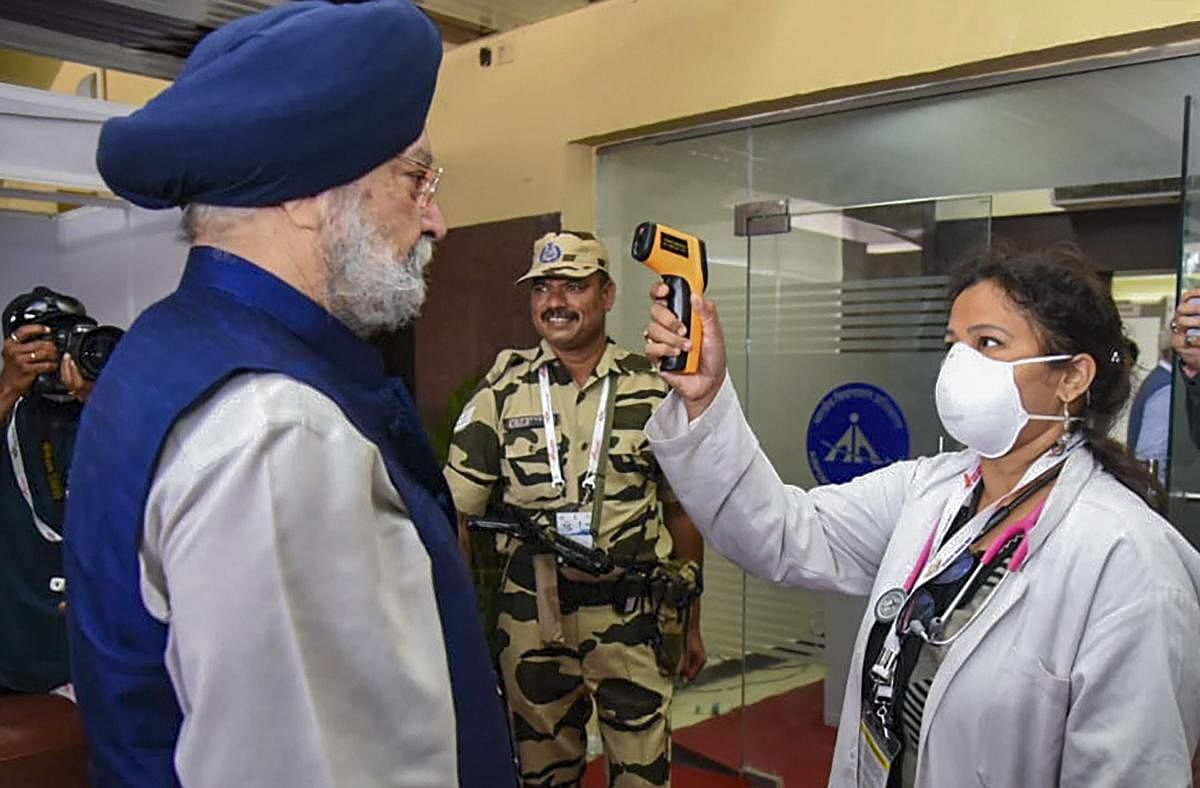 Minister of State for Housing & Urban Affairs, Civil Aviation (Independent Charge) and Commerce & Industry Hardeep Singh Puri being screened by a medic for novel coronavirus (COVID-19), in Hyderabad. (PIB/PTI Photo)