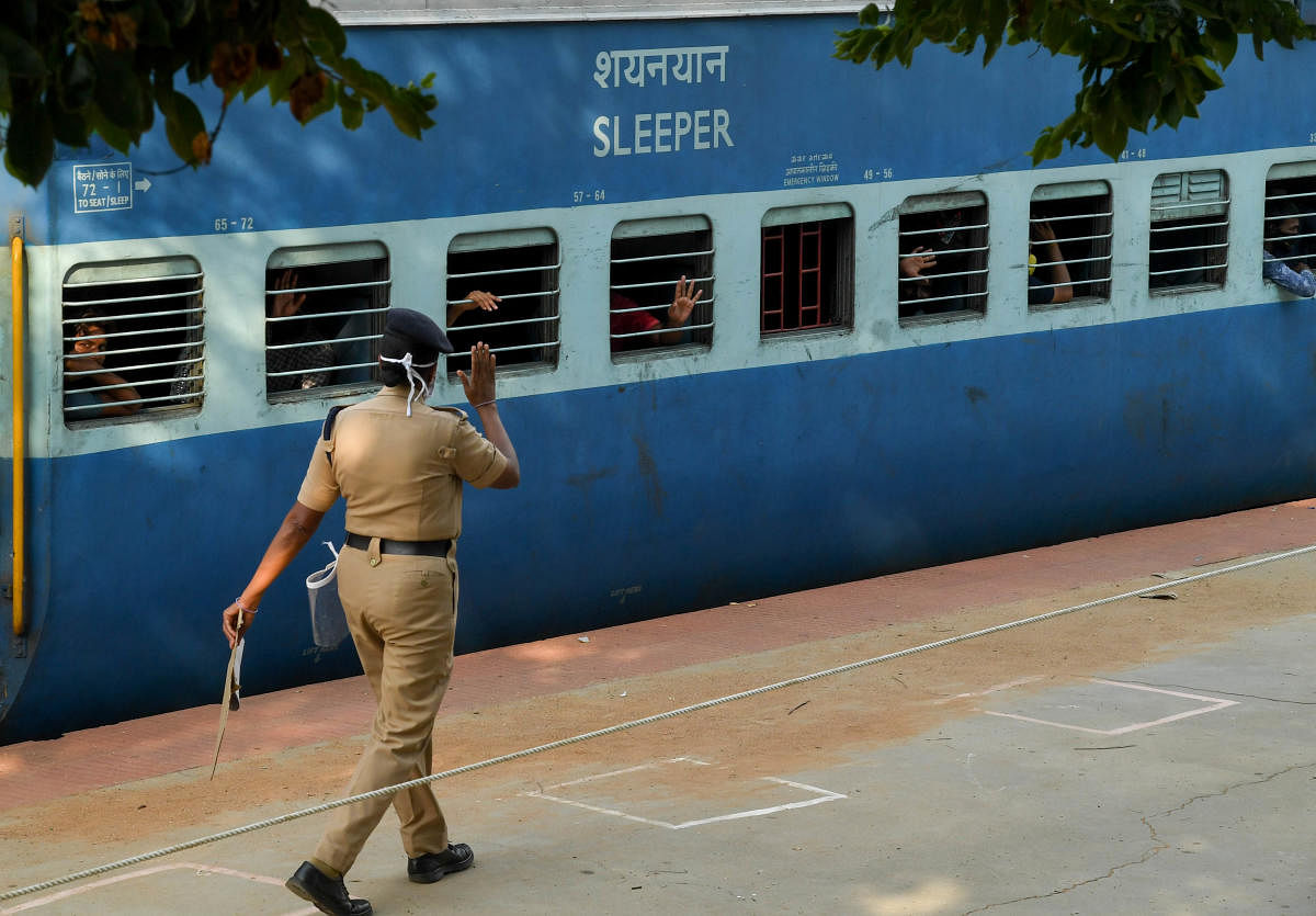 Migrant workers' family waves from a railway compartment while they departure of a special train to Lucknow in Uttar Pradesh state, during a nationwide lockdown, at Chikkabanavara railway station, in Bengaluru on Friday. Photo/ B H Shivakumar