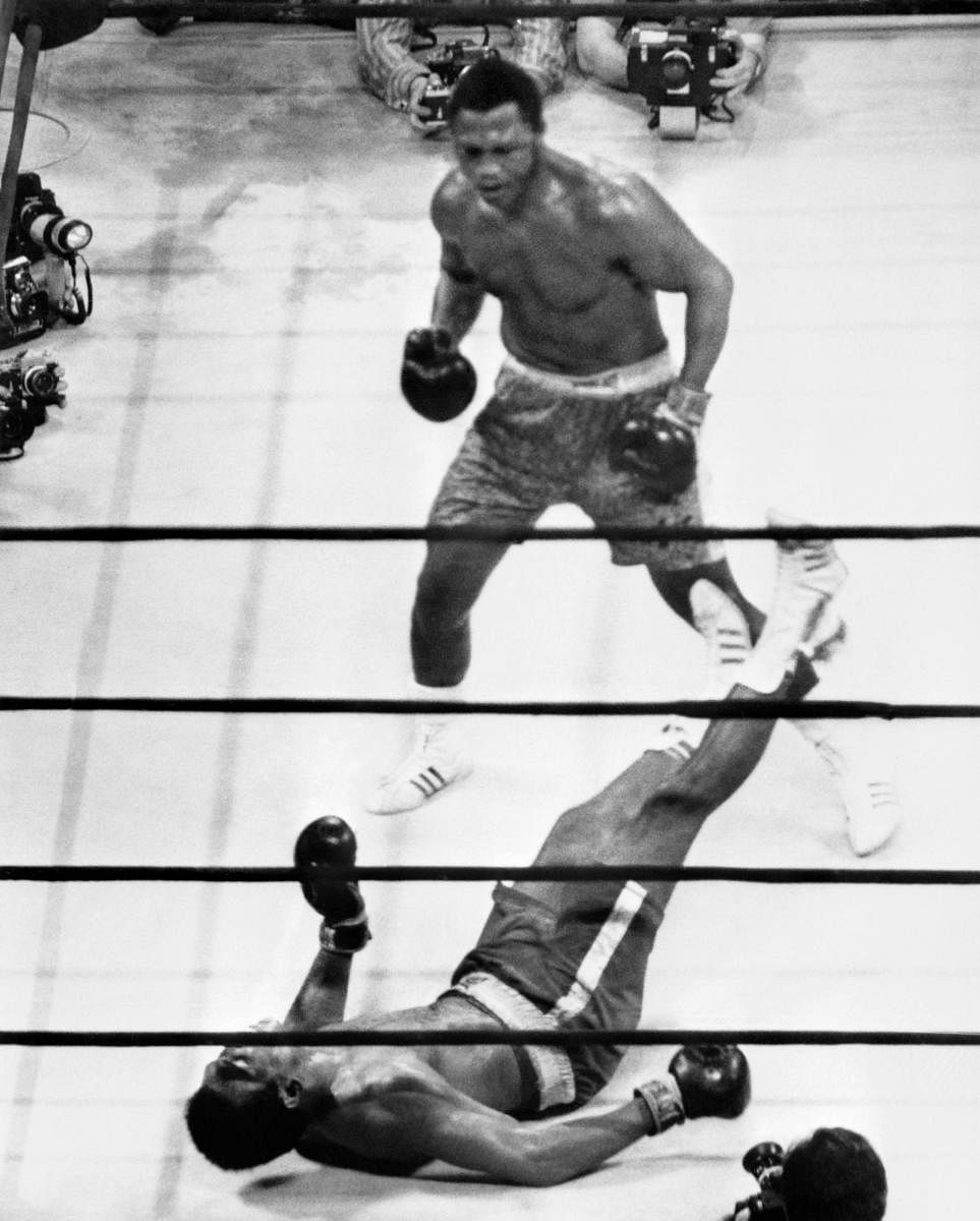 US heavyweight boxing champion Joe Frazier (top) standing over compatriot Muhammad Ali as he wins the fight called the "fight of the century" at Madison Square Garden in New York. - The notoriously brutal "Thrilla in Manila" 45 years ago in 1975, the third of their legendary Ali-Frazier fights after two others in New York, changed the boxing landscape for good, leaving two of the sport's most potent heavyweights Muhammad Ali and Joe Frazier forever diminished, analysts say. (Photo by AFP)