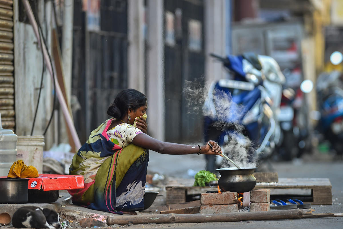A homeless woman cooks food at a roadside, during the complete lockdown to contain the coronavirus spread, in Chennai, Thursday, March 26, 2020. (PTI Photo)