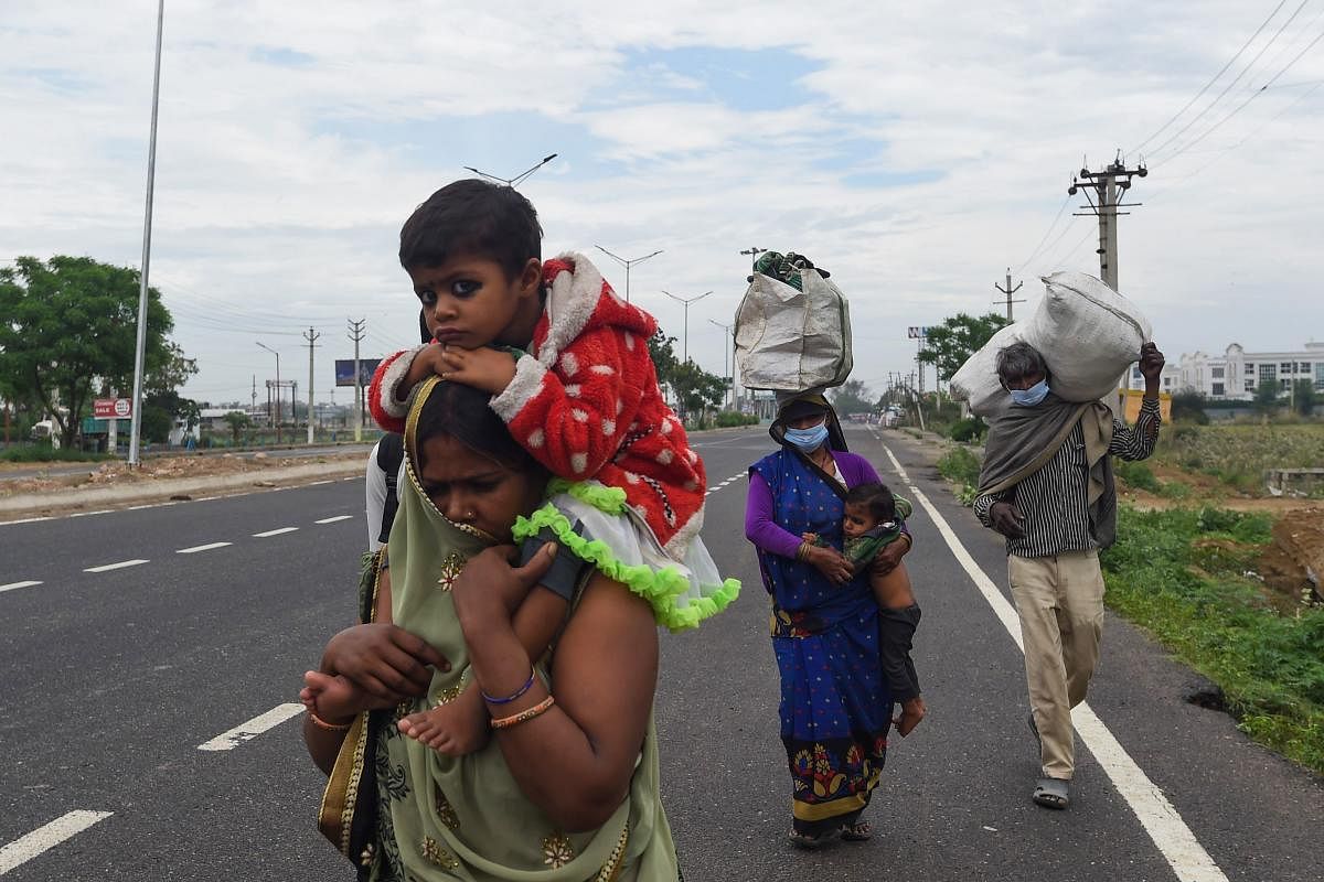 Migrant workers and their family members walk with their belongings amid COVID-19 (AFP Photo)