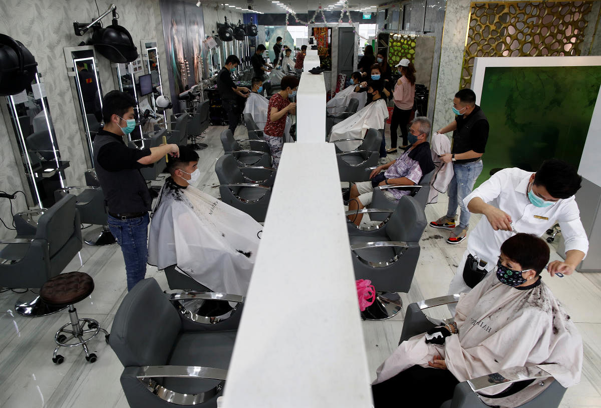People have their haircut at a hairdressing salon as they reopen for business amid the coronavirus disease (COVID-19) outbreak in Singapore. Credit: Reuters Photo