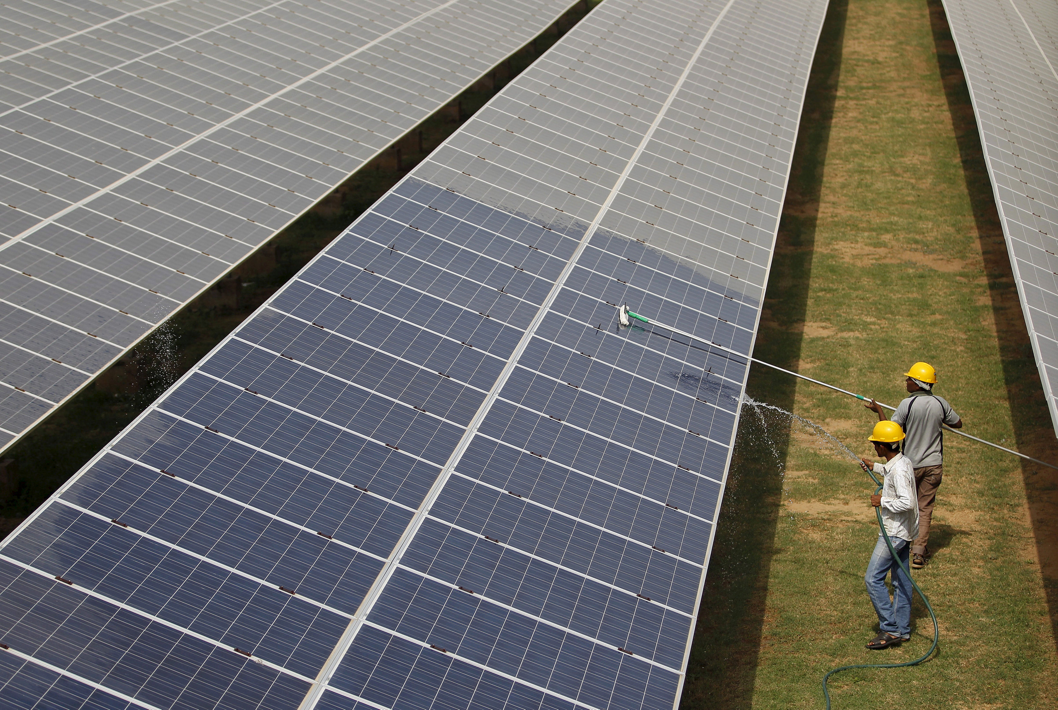  Workers clean photovoltaic panels inside a solar power plant in Gujarat, India. (Reuters)