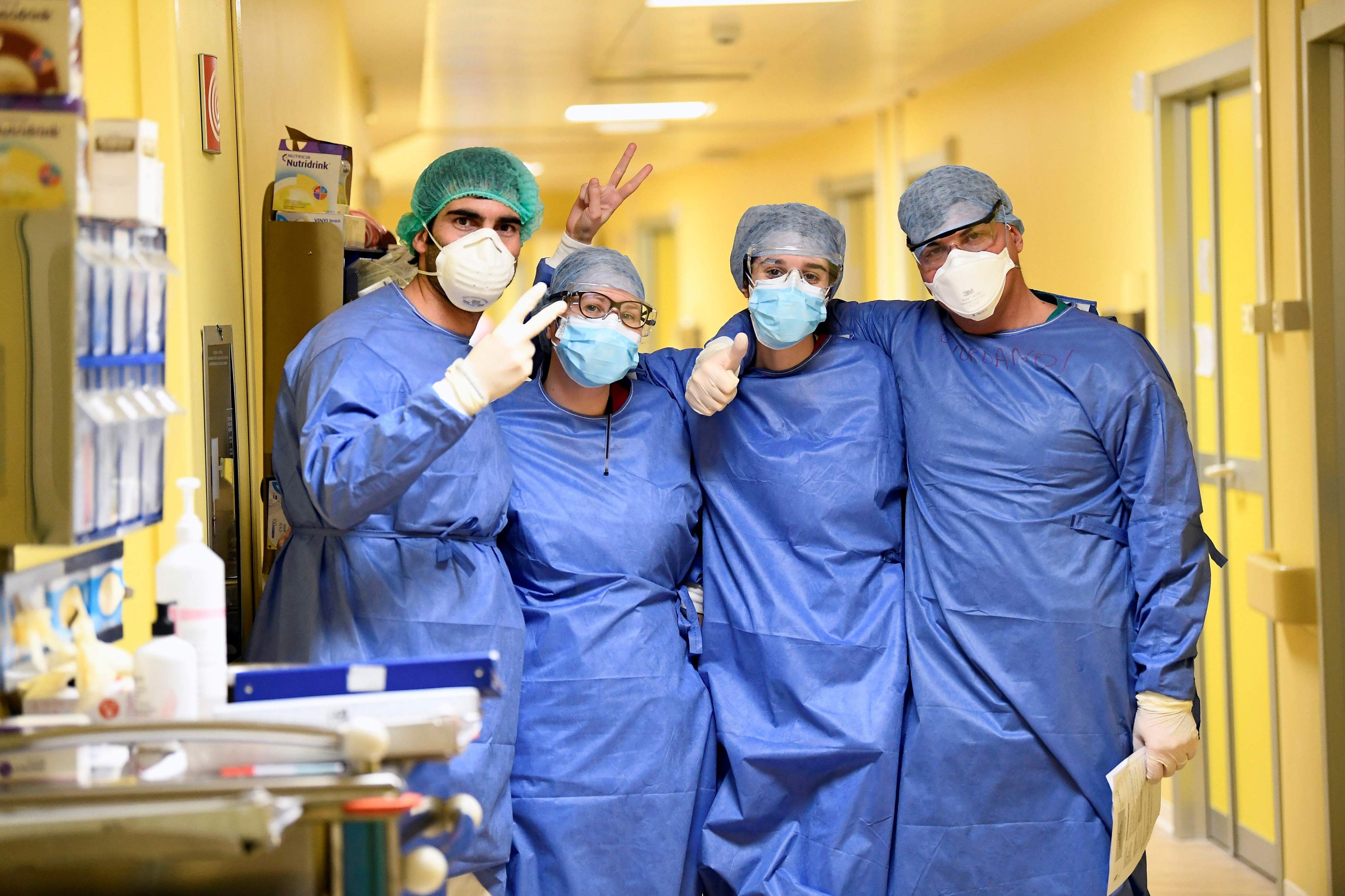 Members of the medical staff in protective suits pose for a photo in the COVID-19 intensive care unit at the San Raffaele hospital in Milan. (Credit: Reuters)