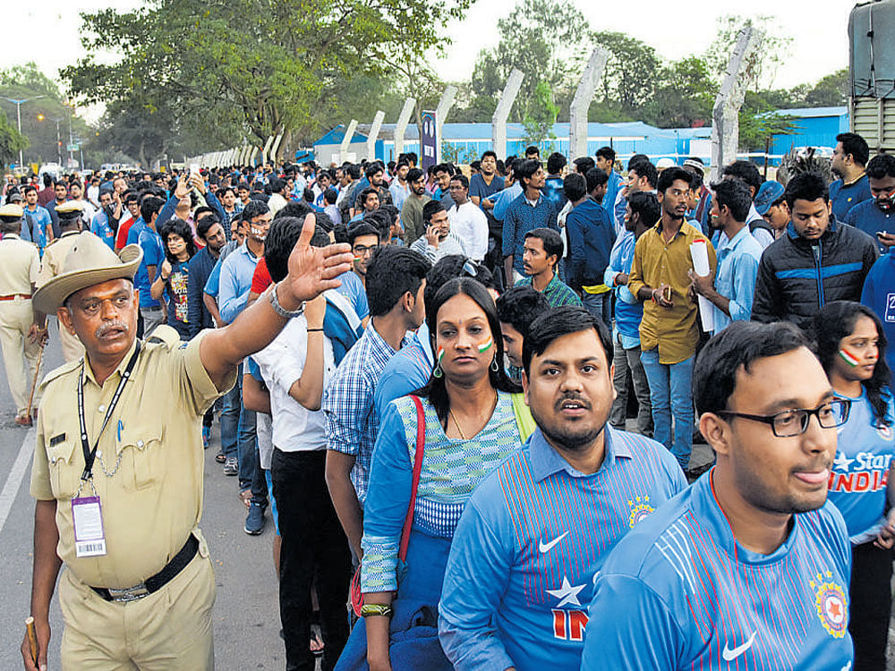 Cricket fans queue up to enter Chinnaswamy Stadium to watch India-England T-20 Cricket match on Wednesday.  DH Photo.