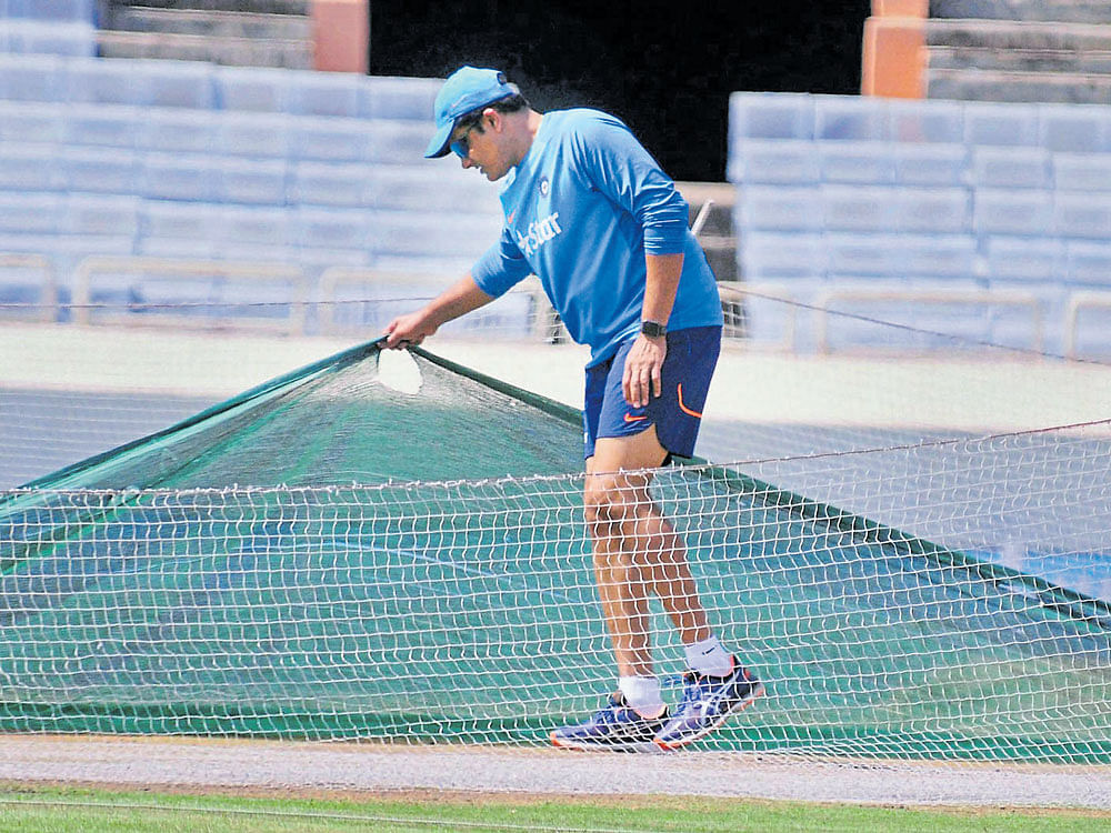 peekaboo!: India's Head Coach&#8200;Anil Kumble checks the pitch at the JIRS Stadium in Ranchi on Tuesday. pti