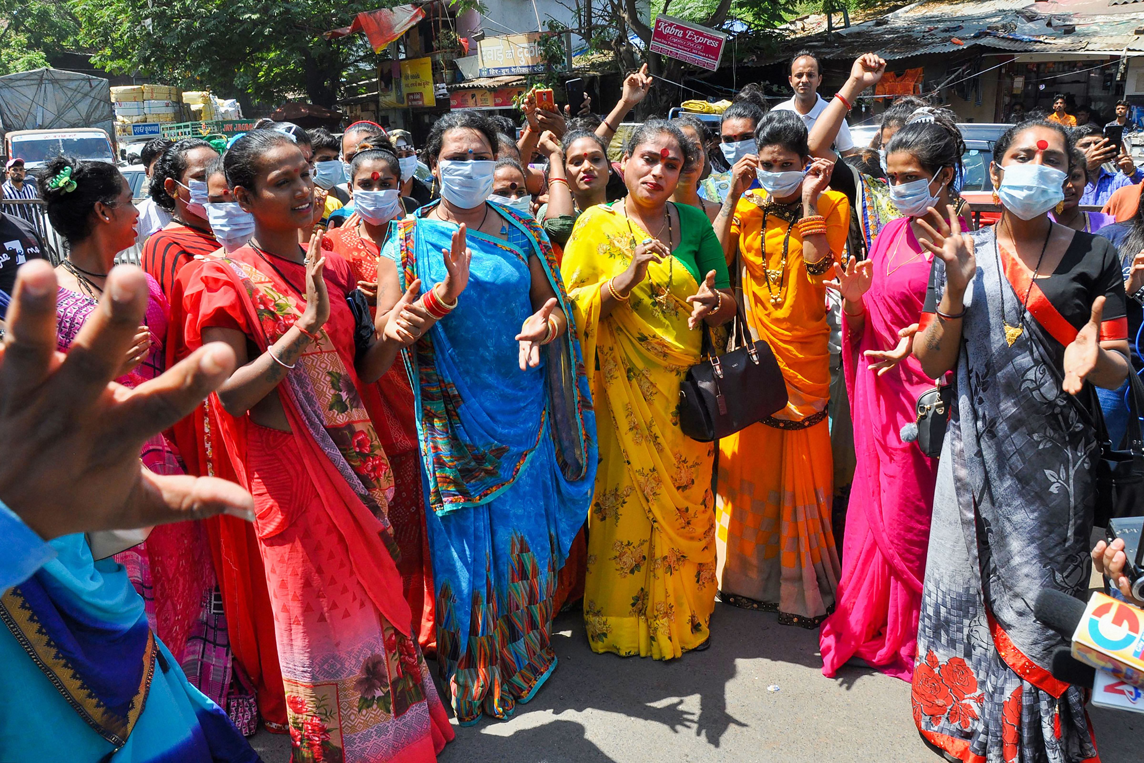 Members of the transgender community distribute masks to commuters to mitigate the coronavirus pandemic, in Surat. (PTI Photo)