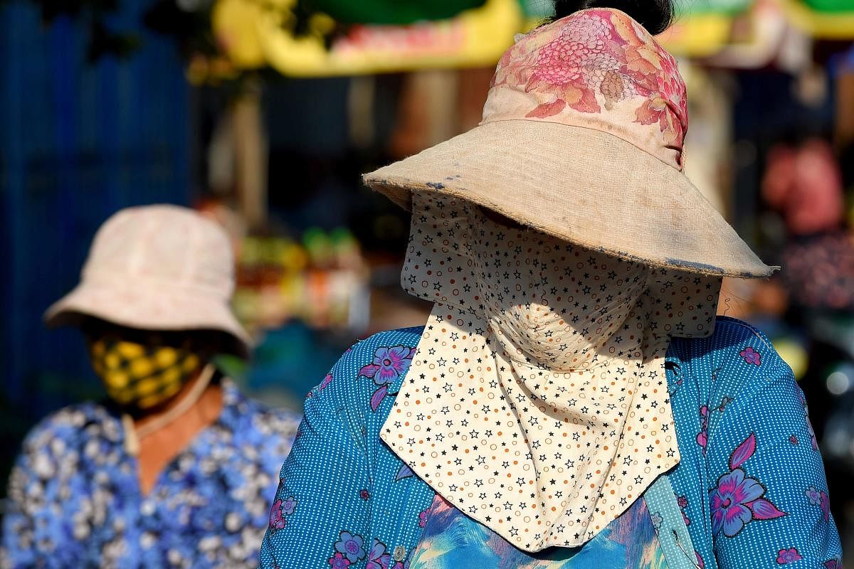 Women wear face masks, amid concerns over a spread of the COVID-19 coronavirus, at a market in Phnom Penh (AFP Photo)