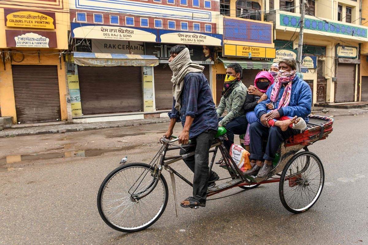 A rickshaw puller transports a patient with relatives to a hospital for a checkup during a government-imposed nationwide lockdown as a preventive measure against the COVID-19. PTI