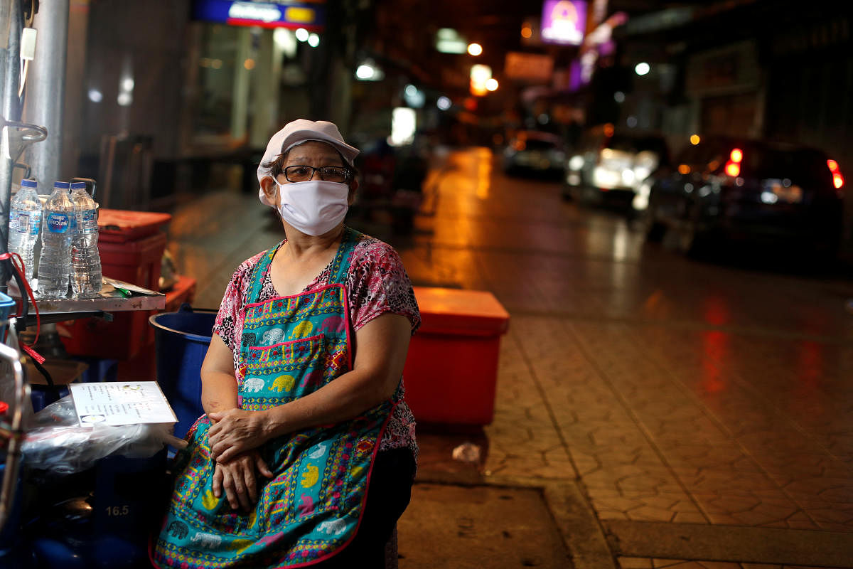 A woman wearing a mask waits for customers at an empty food stall during the coronavirus disease (COVID-19) outbreak, in Chinatown, Bangkok. Credit: Reuters Photo