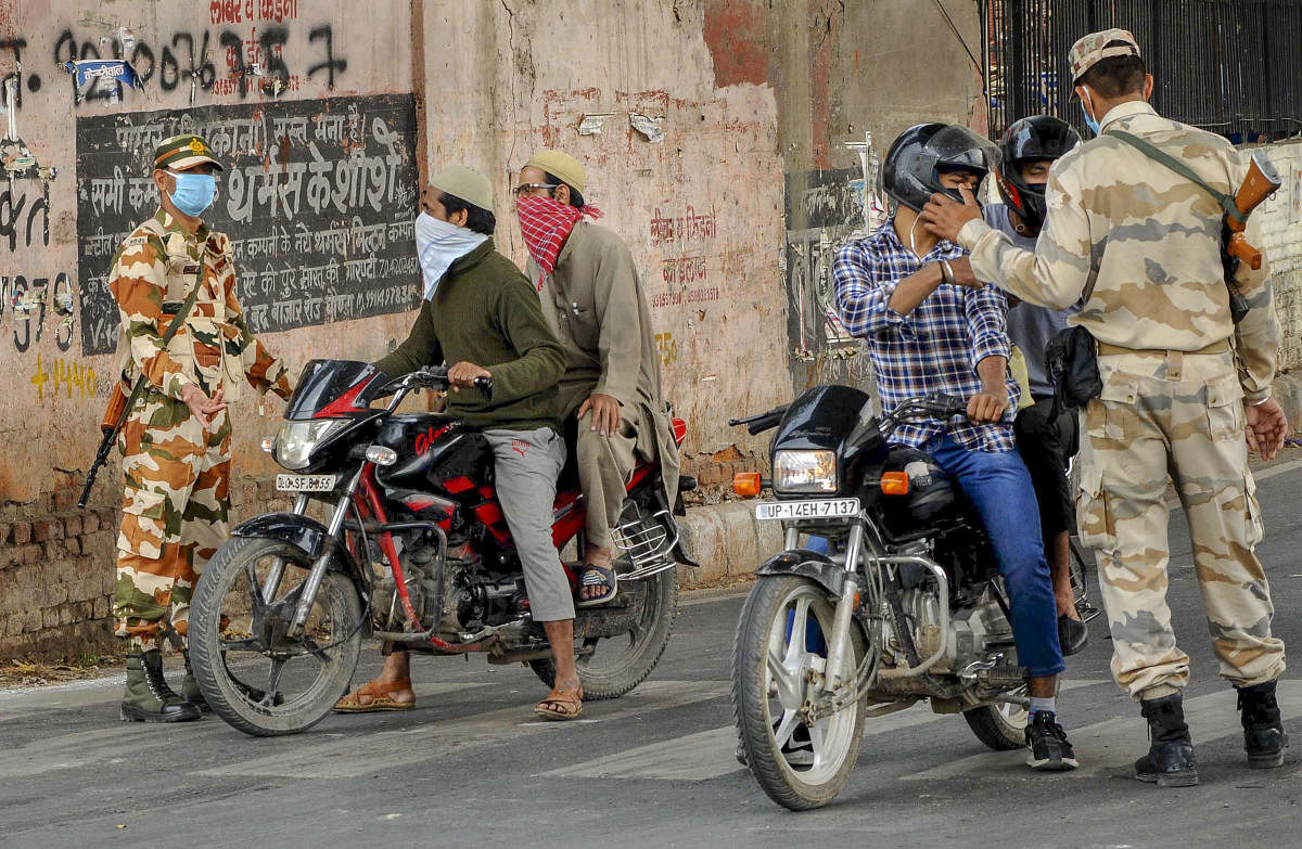 Police personnel stop commuters after the state government enforced lockdown in the city amid coronavirus pandemic, in Jafrabad area of northeast Delhi, Tuesday, March 24, 2020. (PTI Photo)