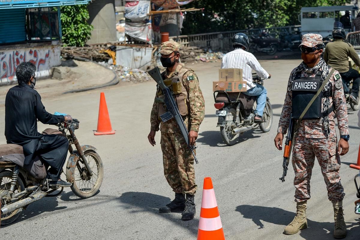 Security personnel stand guard at a checkpoint during a government-imposed nationwide lockdown as a preventive measure against the COVID-19 coronavirus, in Karachi. AFP