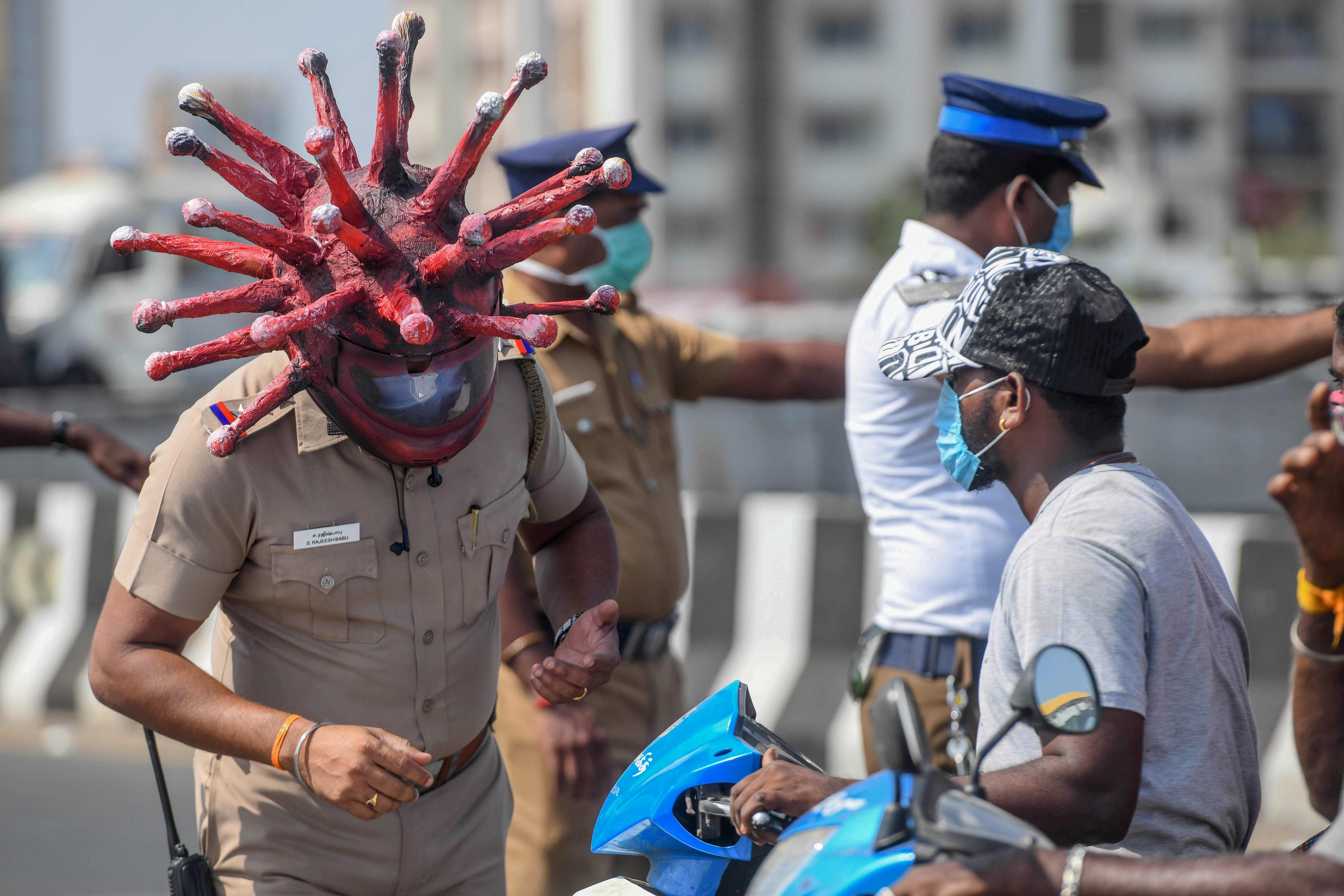 Police inspector Rajesh Babu (L) wearing coronavirus-themed helmet. (AFP Photo)
