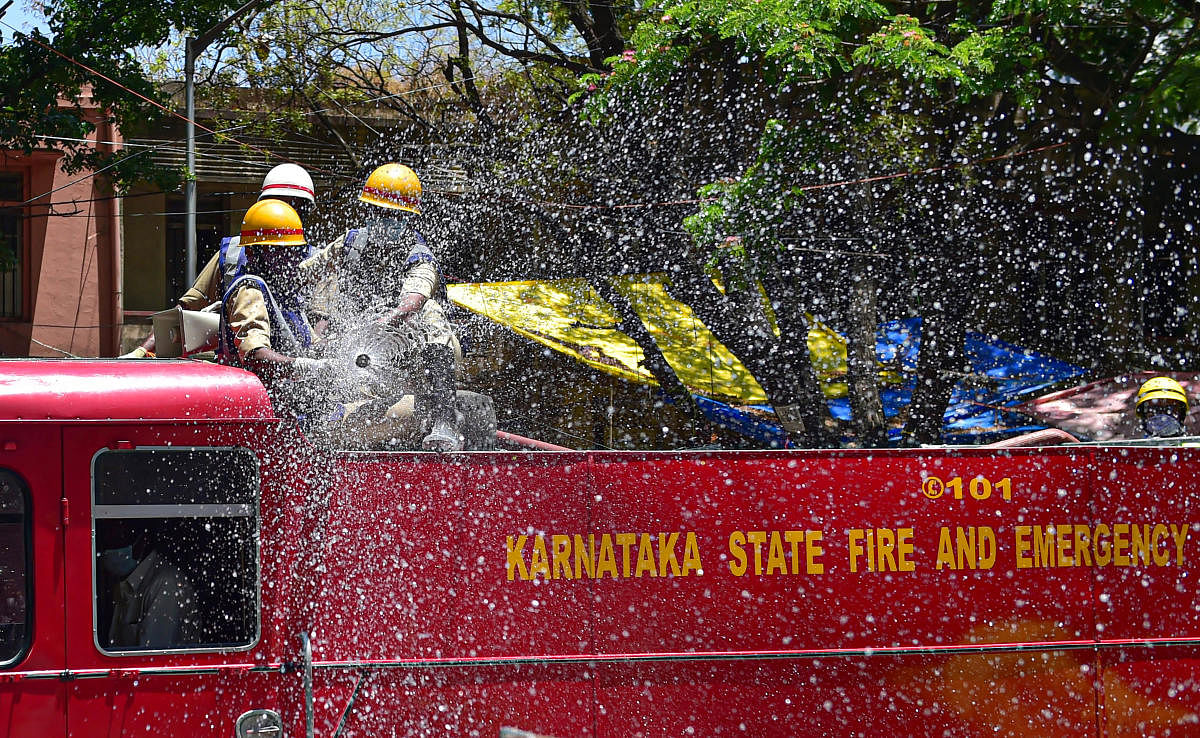 Fire fighters spray disinfectant to sanitise a road during a nationwide lockdown, imposed in the wake of coronavirus pandemic, in Bengaluru, Saturday, March 28, 2020. (PTI Photo)