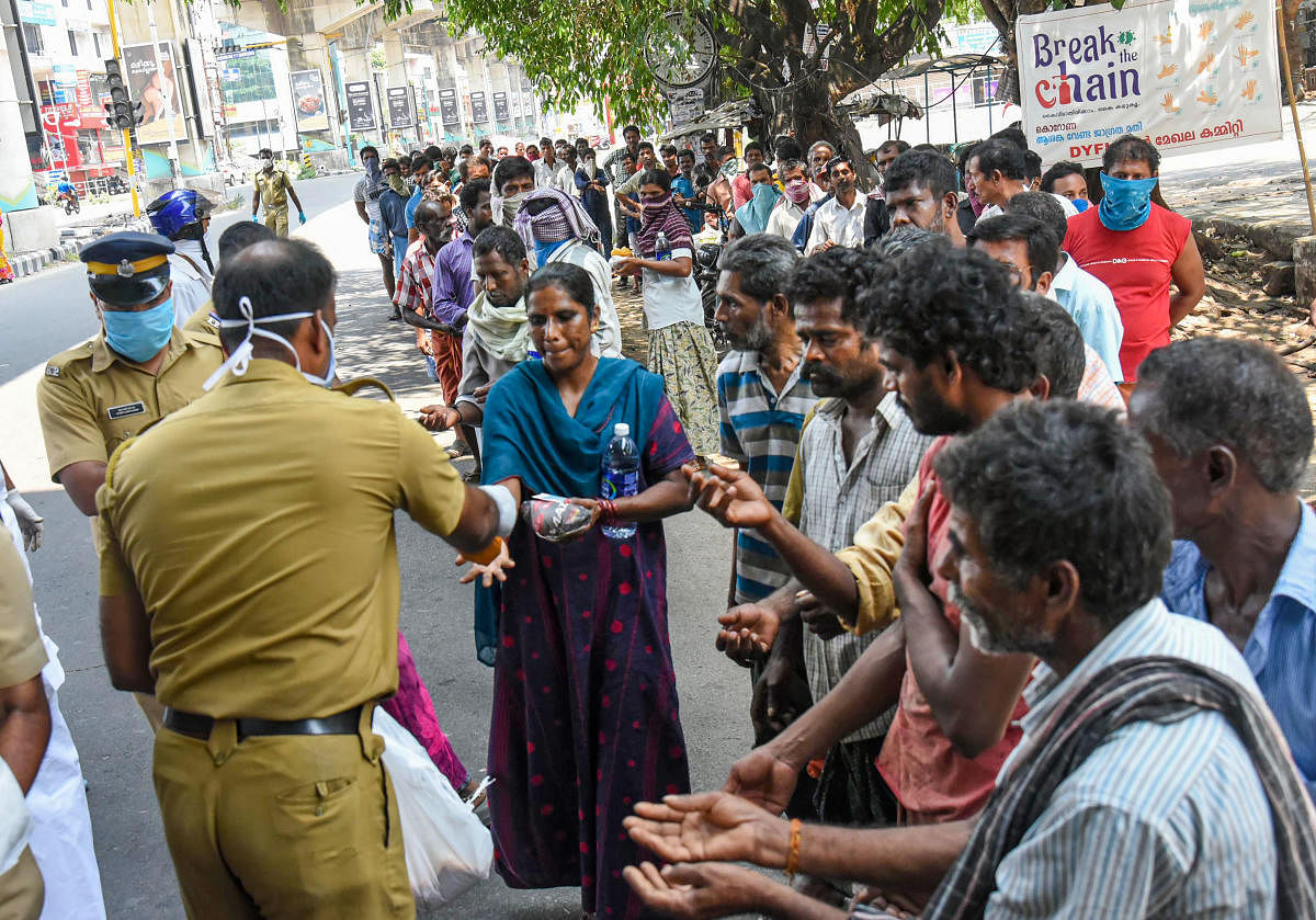 Police and social workers distribute packaged food among homeless and needy people during the nationwide lockdown in the wake of coronavirus pandemic, in Kochi, Monday, March 30, 2020. (PTI Photo)