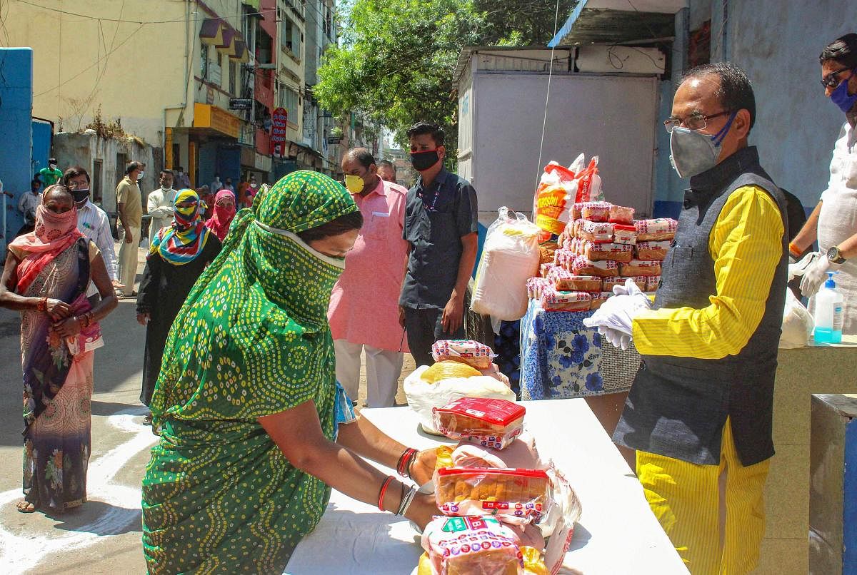 Madhya Pradesh Chief Minister Shivraj Singh Chouhan distributes food packets among poor people during a nationwide lockdown in the wake of coronavirus pandemeic, in Bhopal, Monday, March 30, 2020. (PTI Photo)