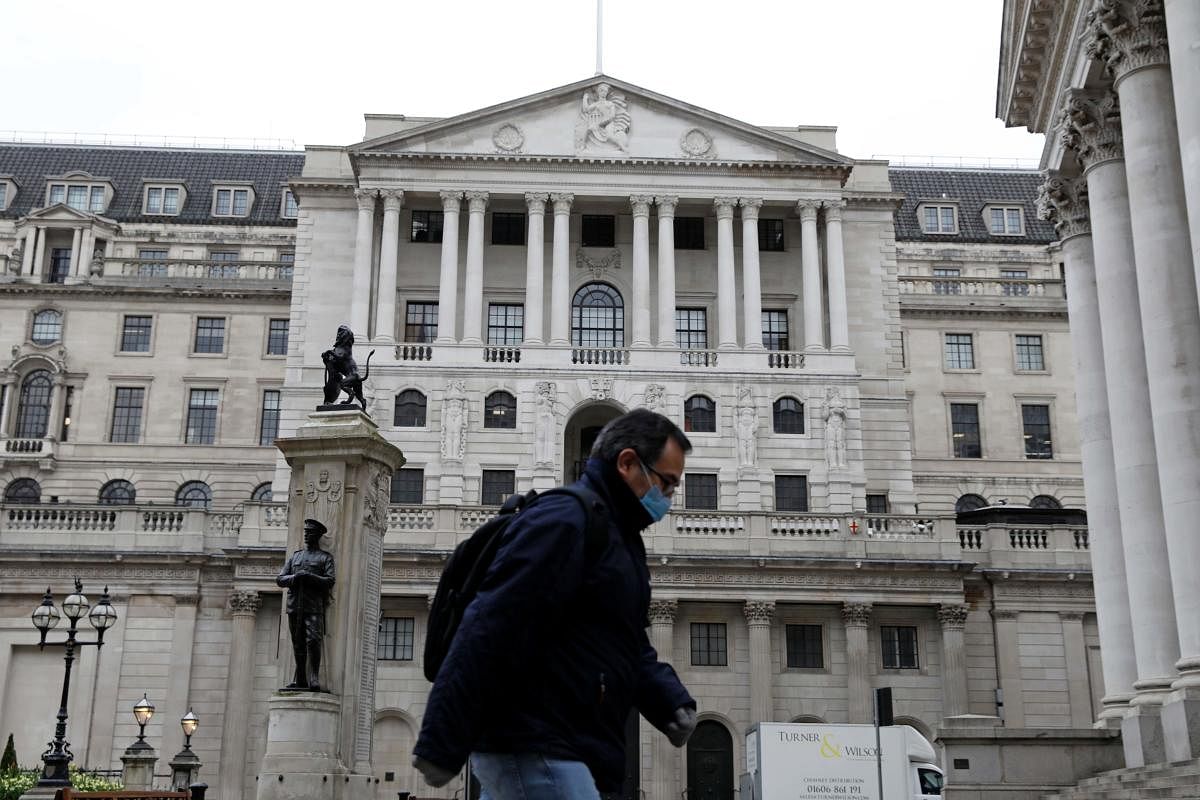 A man wearing protective face mask walks past the Bank of England. AFP