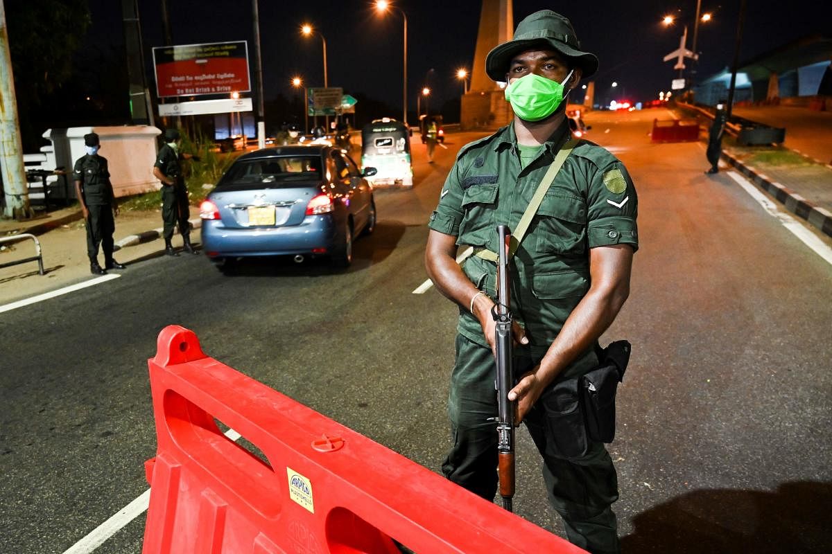 A soldier wearing a facemask stands guard at a checkpoint during a nationwide curfew imposed as a preventive measure against the spread of the COVID-19 novel coronavirus in Colombo. (AFP Photo)