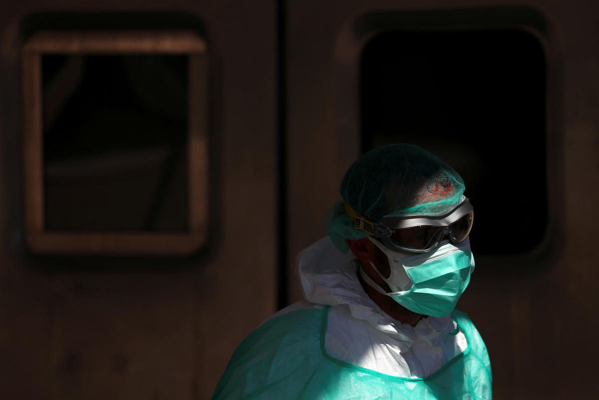 A healthcare worker wearing protective face mask, goggles and suit walks near the entrance of the emergency unit at 12 de Octubre hospital during the coronavirus disease (COVID-19) outbreak in Madrid, Spain. (REUTERS Photo)