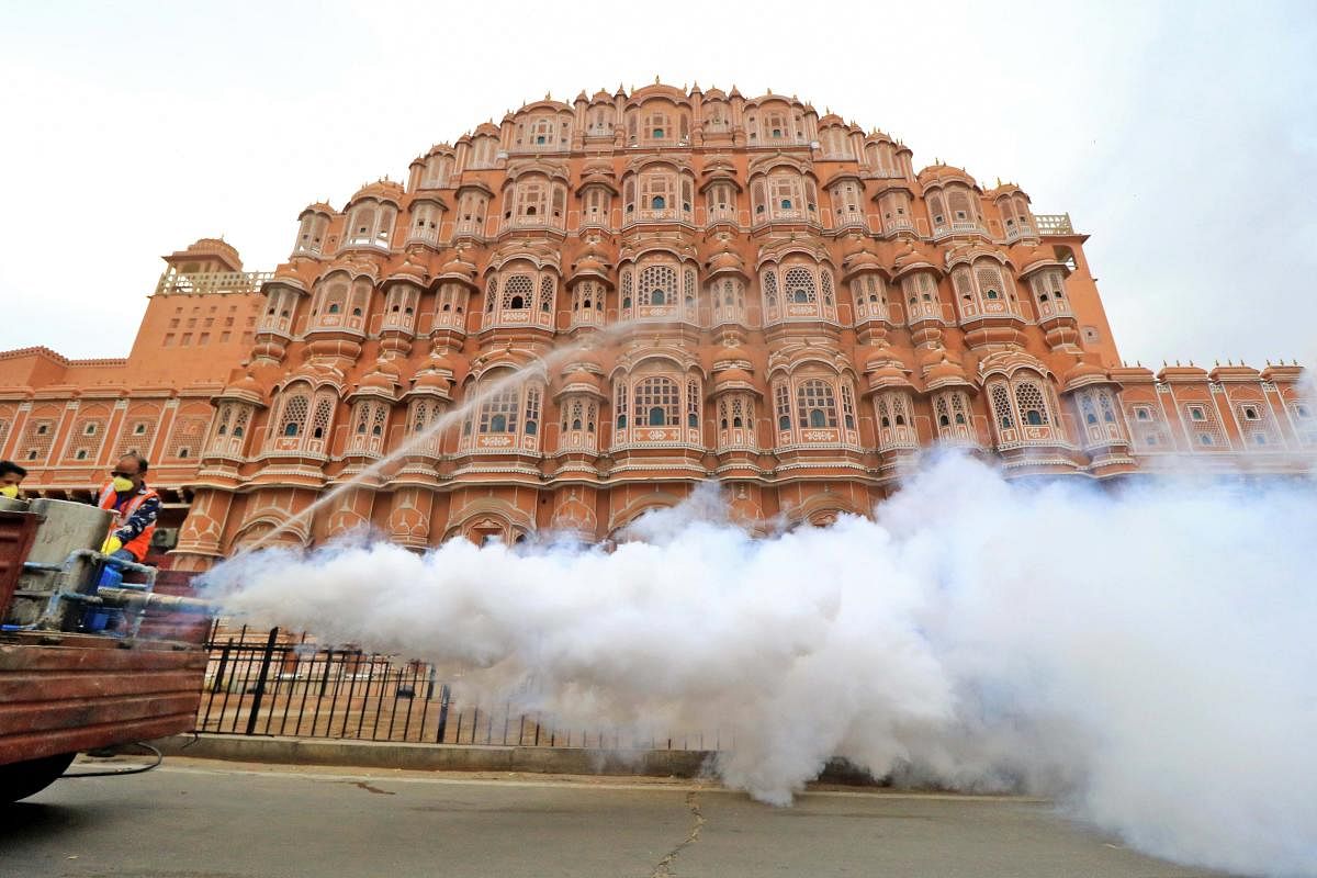 JMC workers fumigate the area around Hawa Mahal as a precautionary measure to contain the spread of coronavirus, during the nationwide lockdown, in Jaipur, Tuesday, March 31, 2020. (PTI Photo)